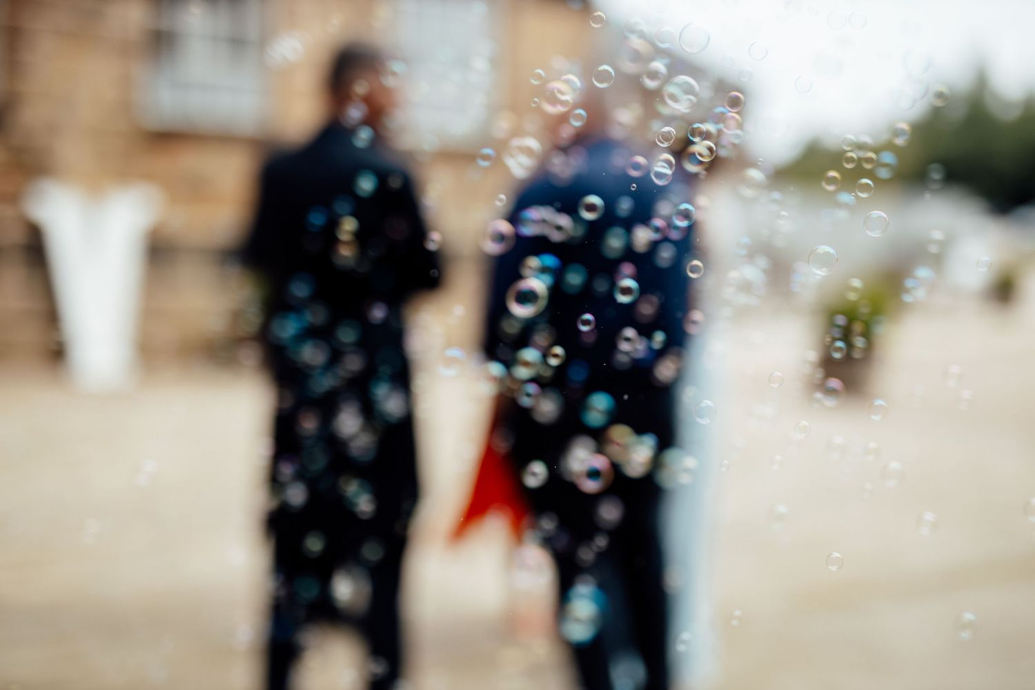 Playful scene with soap bubbles floating through the air outdoors.