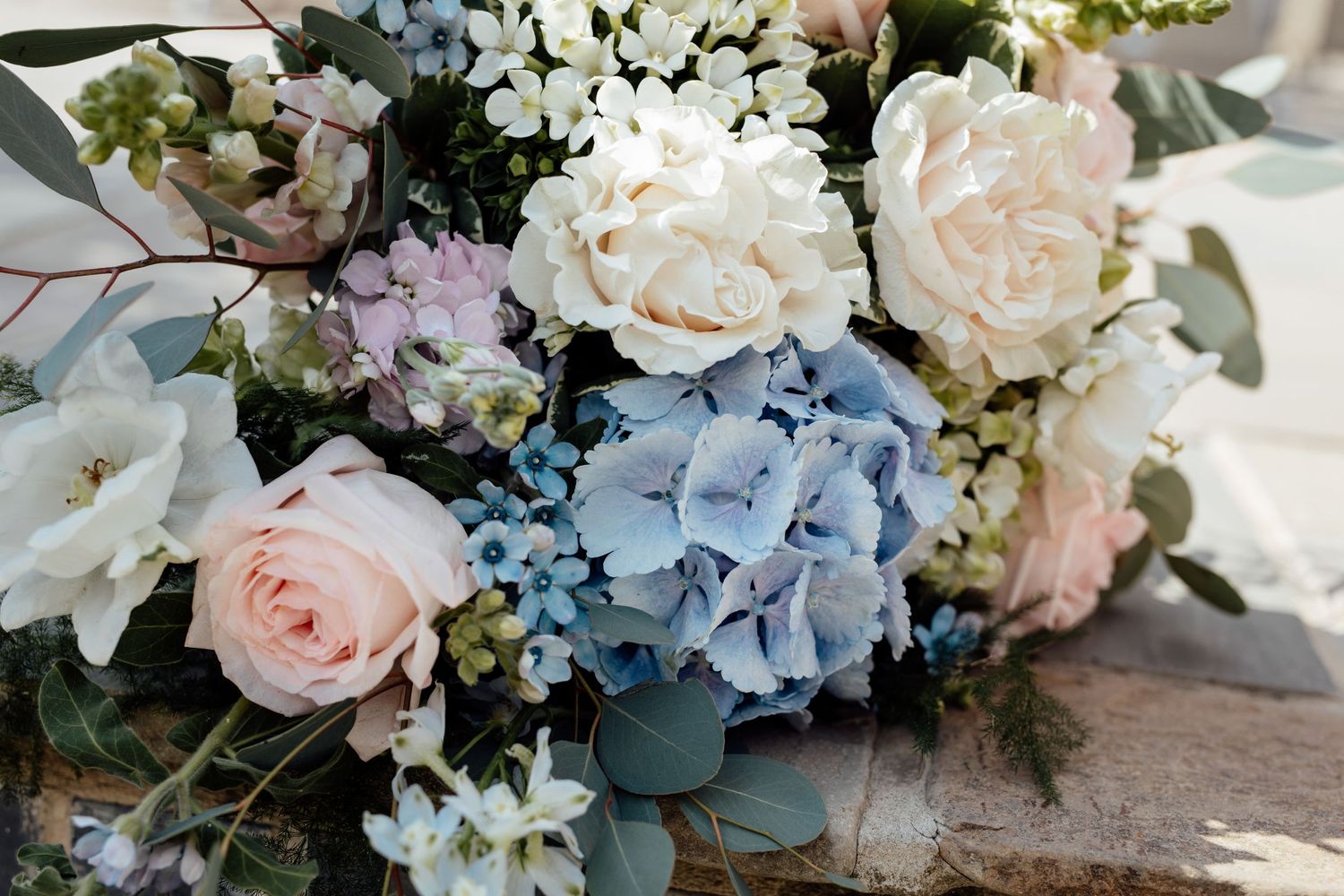 Elegant wedding floral arrangements with blue hydrangeas and white roses.