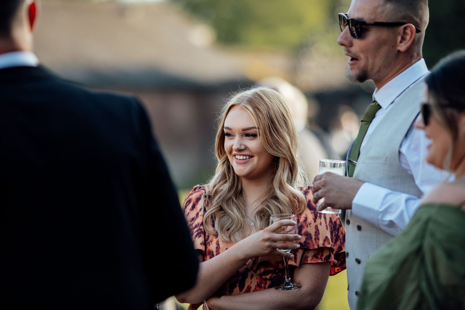 Wedding guests mingle and socialize during an outdoor reception.
