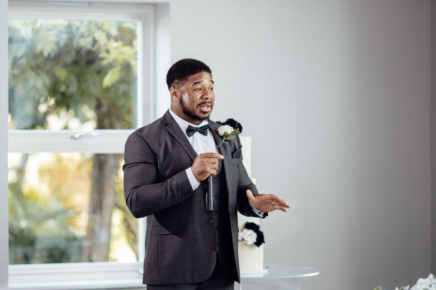 A speaker delivers a speech during a formal wedding reception.