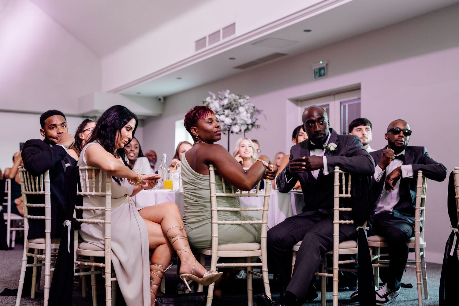 Wedding reception setup with white chairs in an indoor venue.