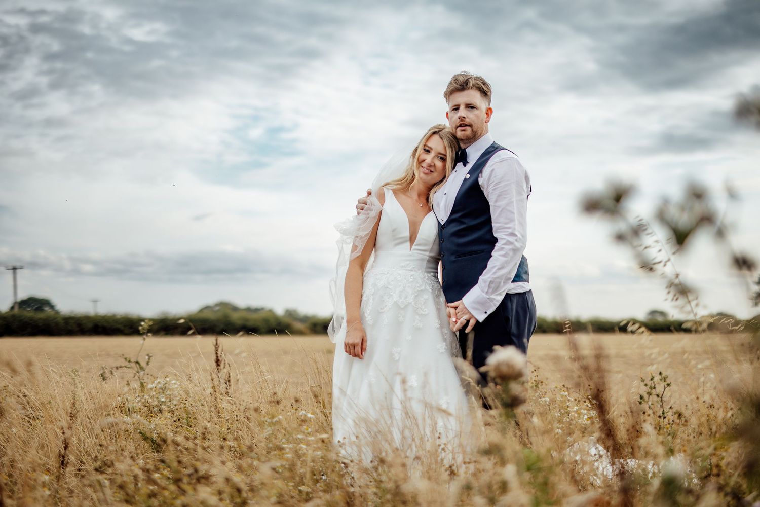 Romantic couple portraits in a golden wheat field on their wedding day.