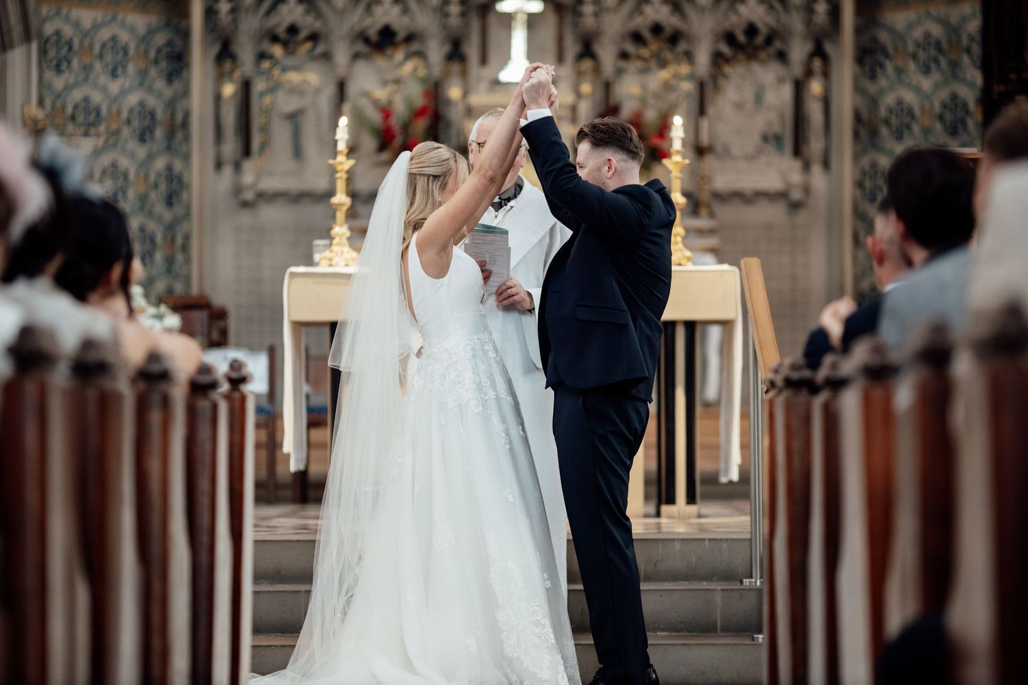 Traditional church ceremony with gothic architecture and wooden pews.