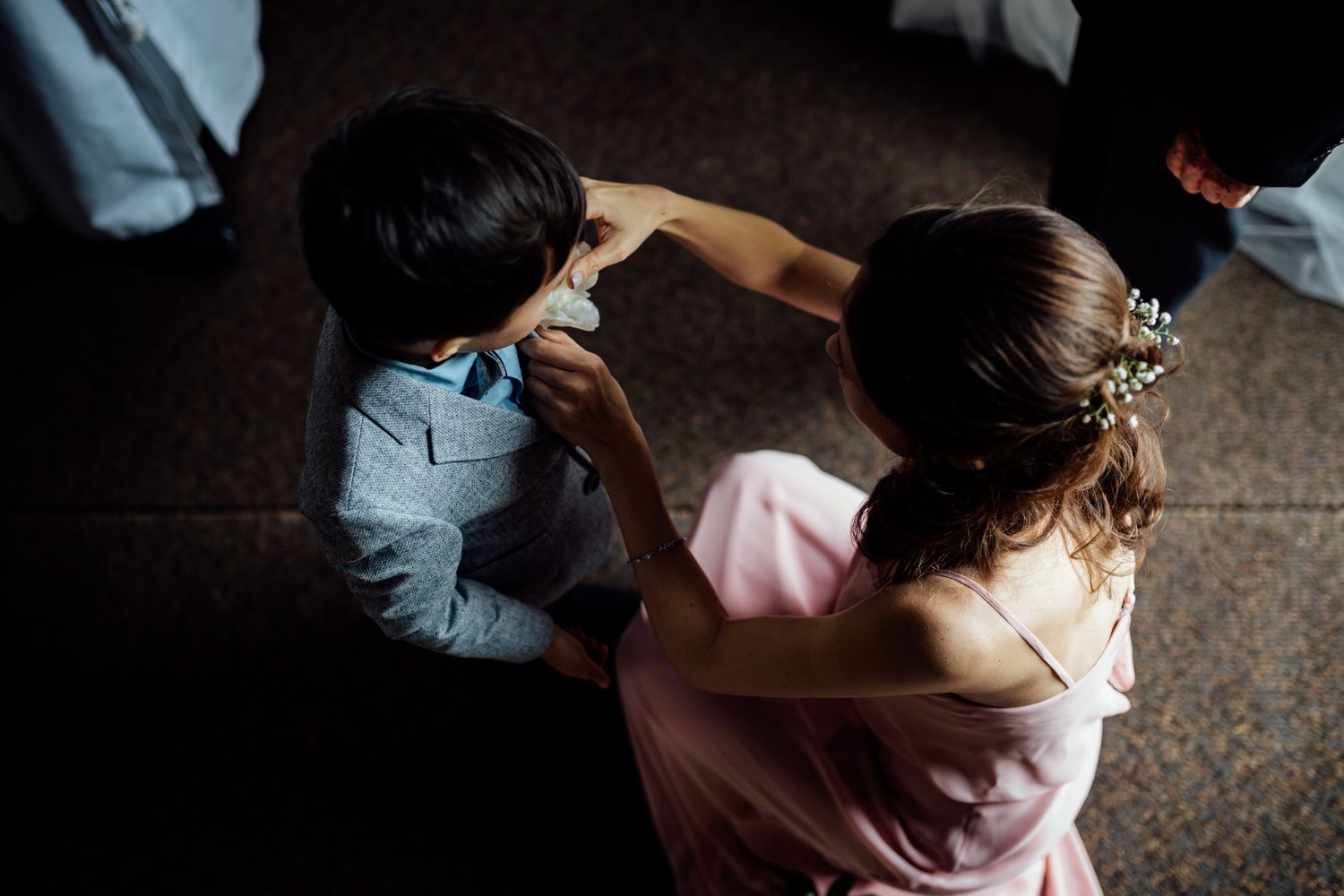 Wedding party members in pink dresses preparing in dramatic lighting.