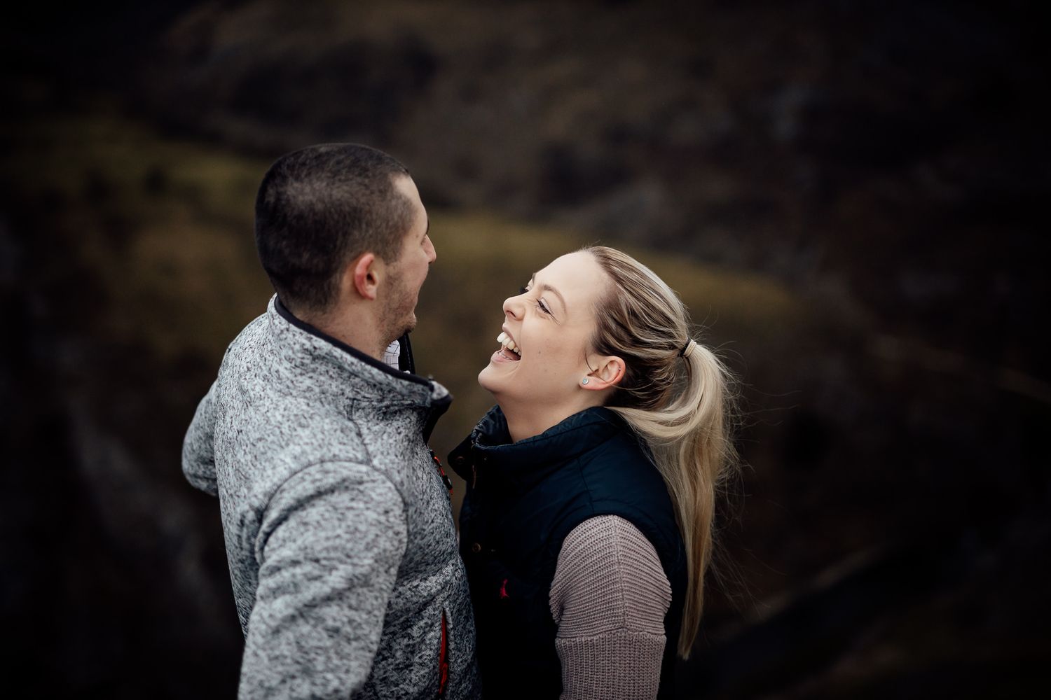 A tender moment captured between a couple in casual winter wear outdoors.