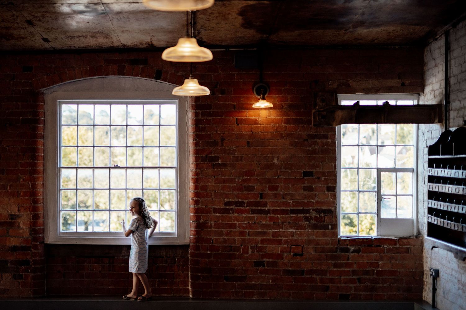Industrial-style wedding venue with exposed brick walls and vintage pendant lights casting warm glows.
