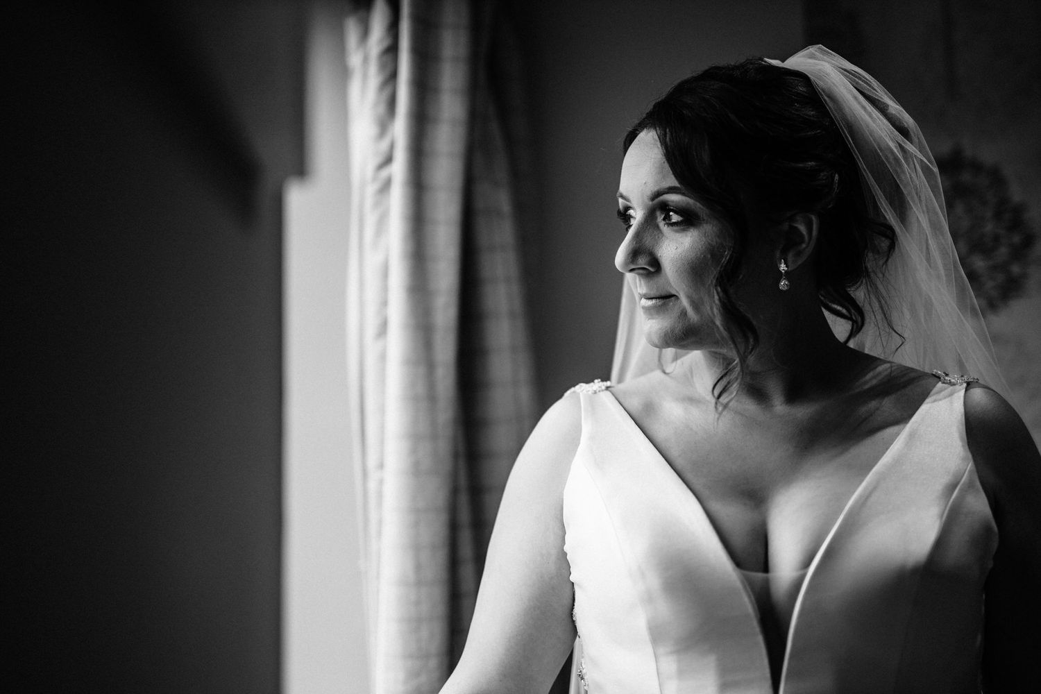 Black and white bridal portraits captured near a window with natural light.
