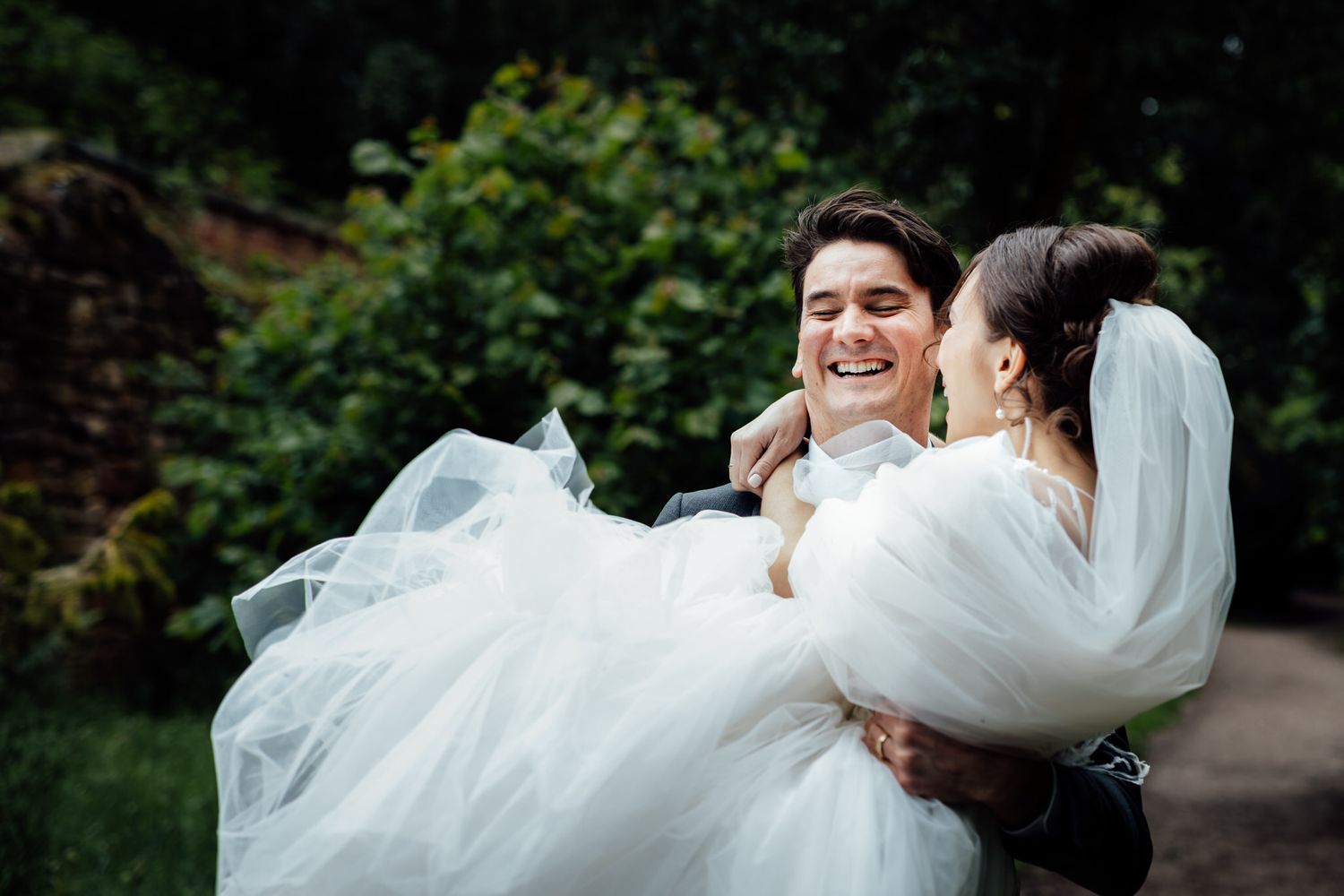 Joyful wedding moment captured as couple embraces outdoors.