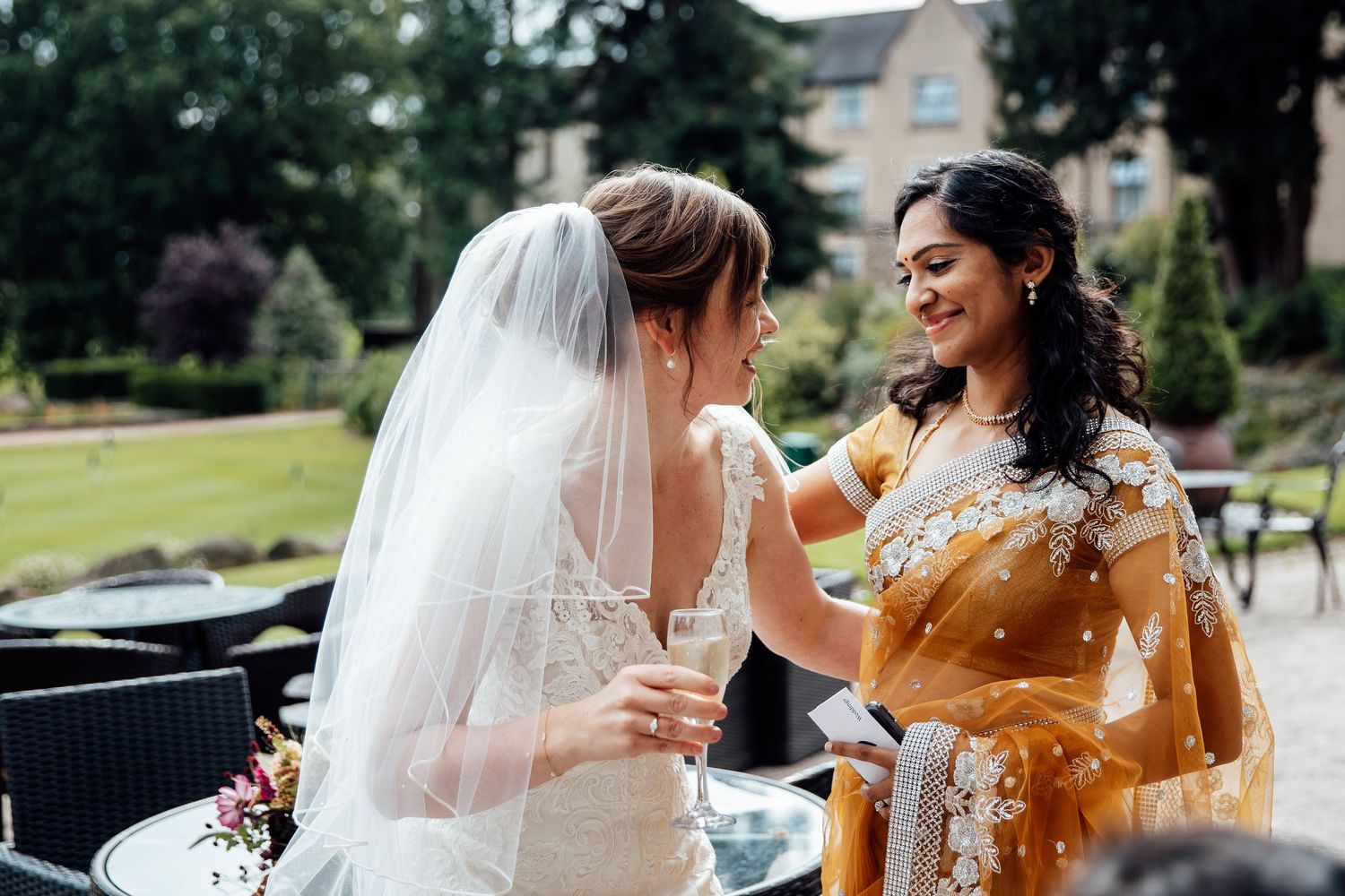 Wedding celebration on a garden lawn with guests in formal attire.