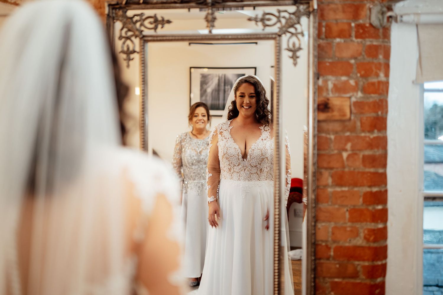 Wedding ceremony setup in rustic brick venue with elegant white decor and pendant lighting.