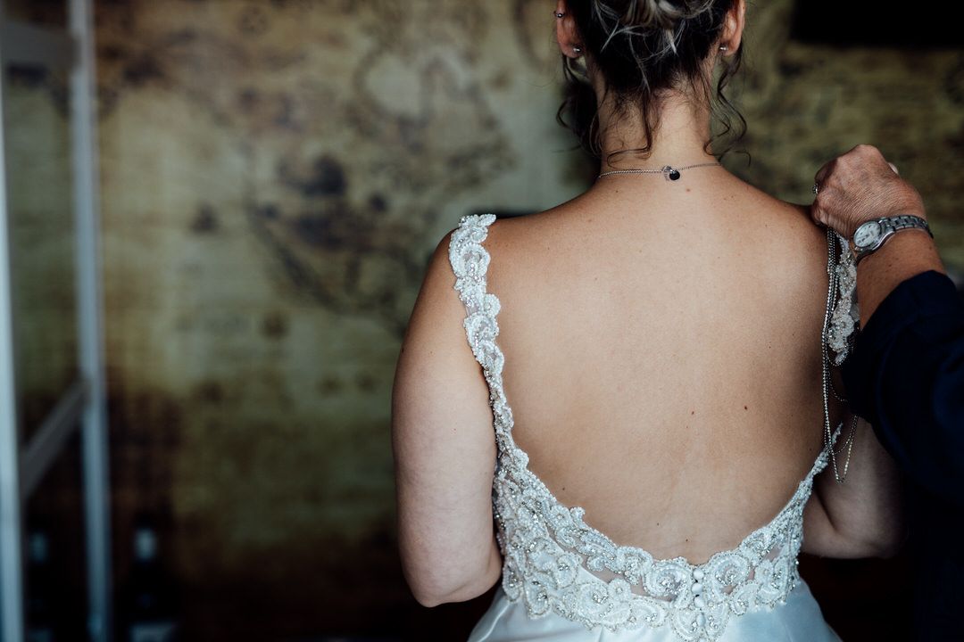 Back detail of a lace wedding dress with intricate embroidery patterns.