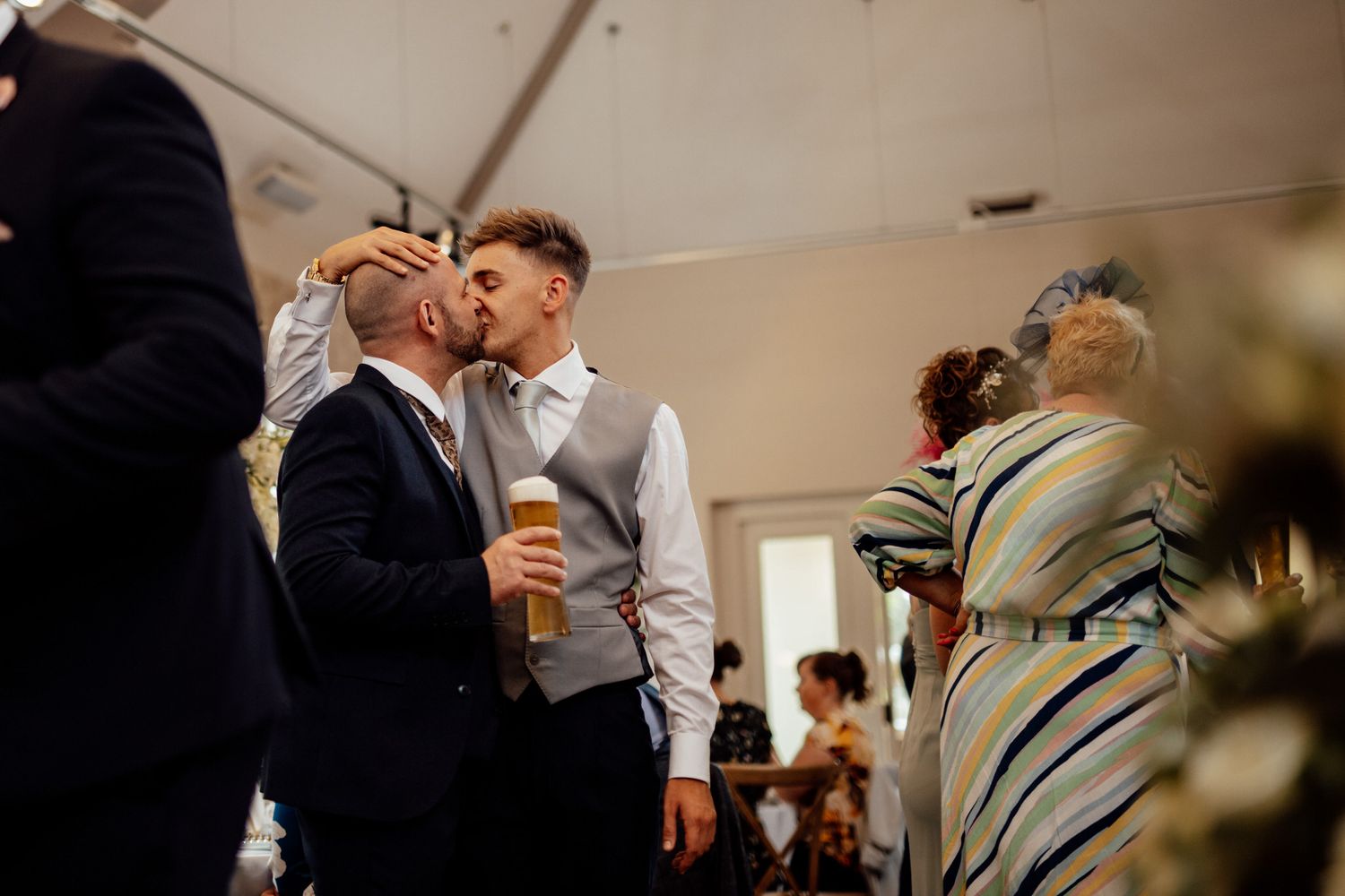 Wedding celebration in an indoor venue with guests mingling and socializing.