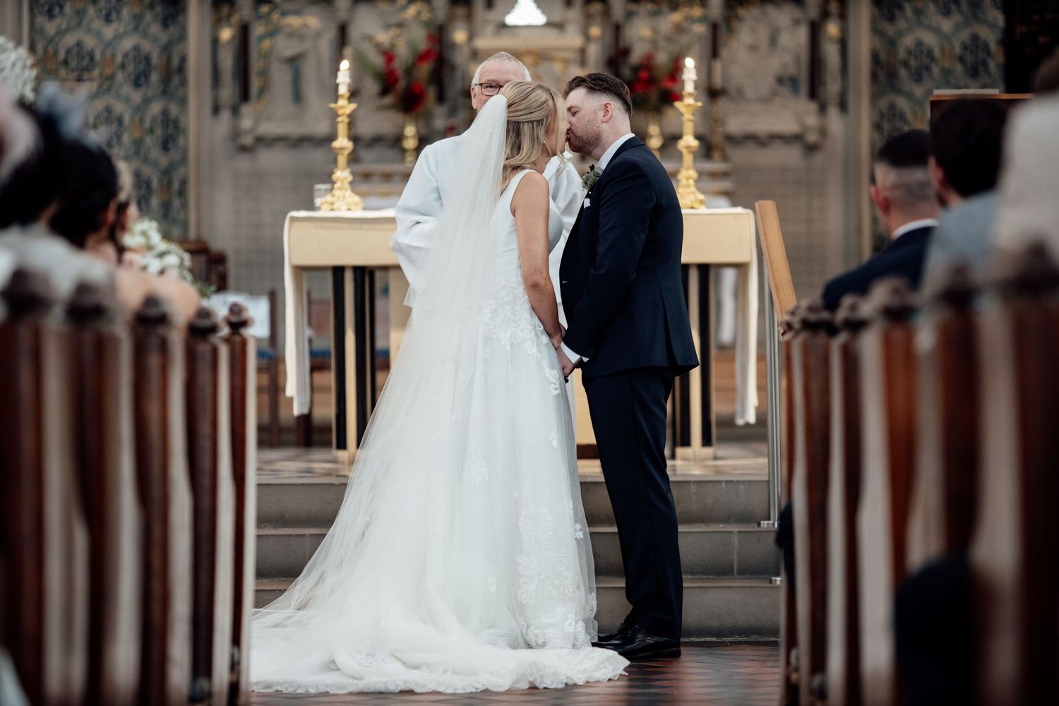 Wedding ceremony in a traditional church with ornate architectural details.
