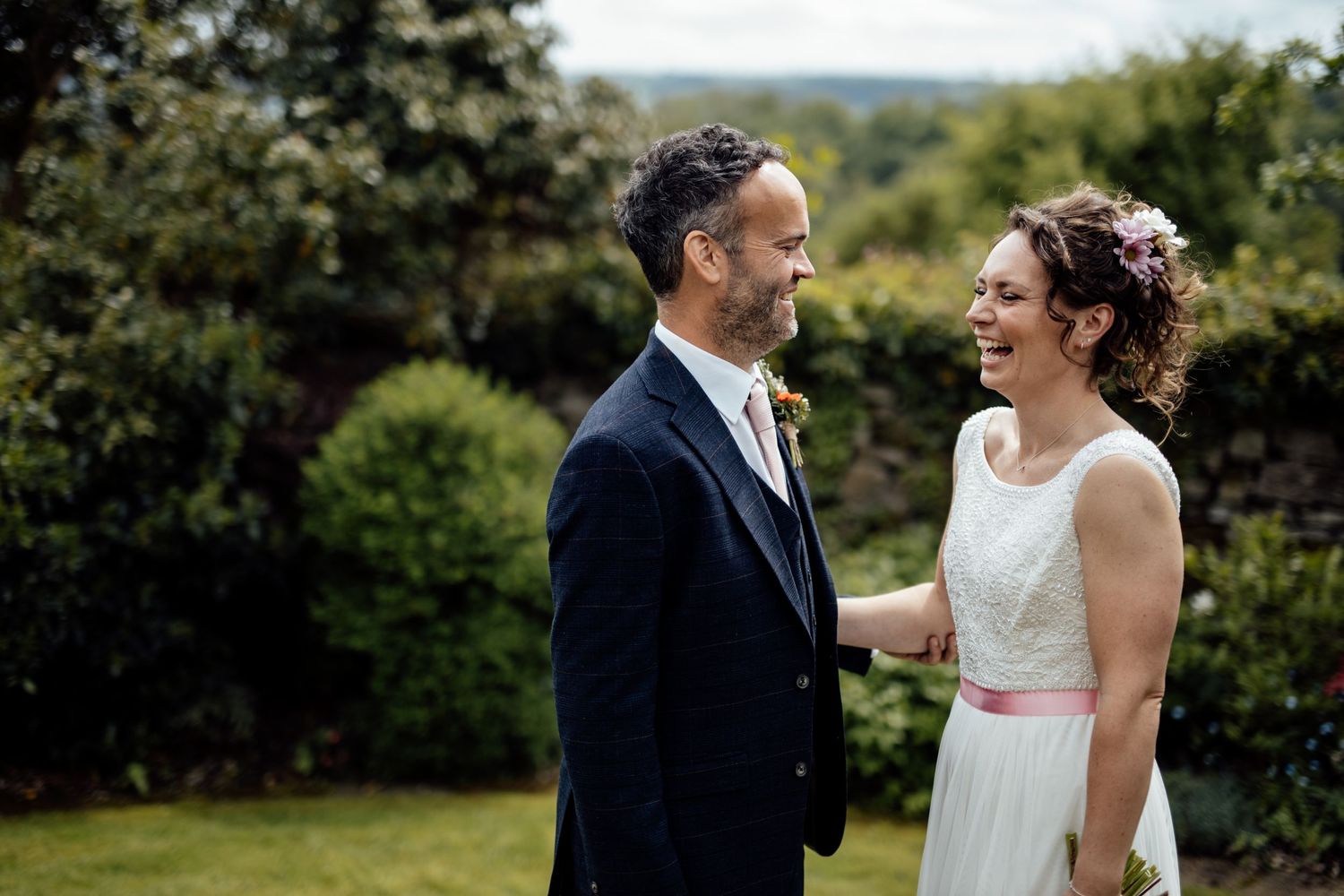 A couple shares an intimate moment in a scenic countryside setting.
