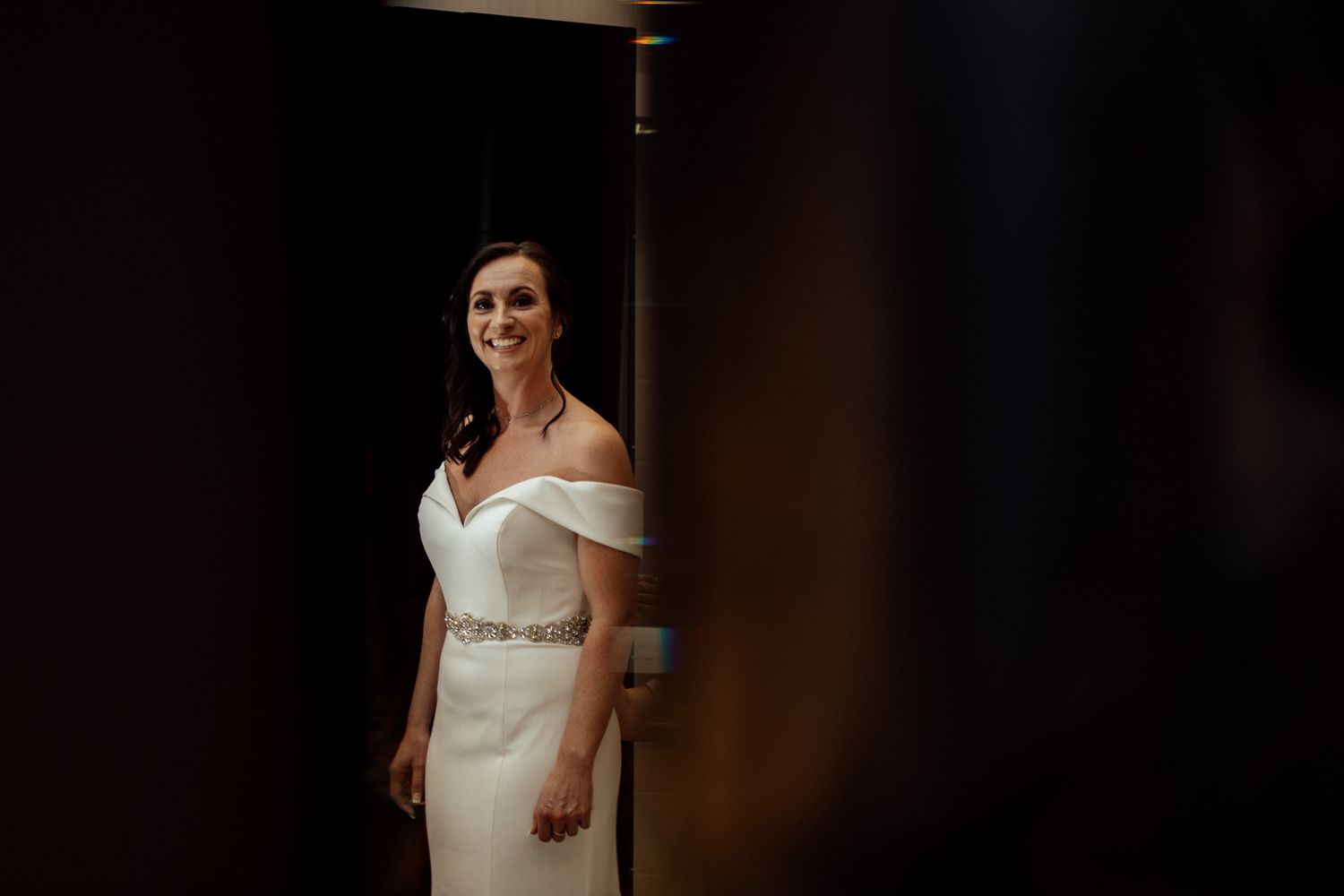 A wedding ceremony moment captured in dramatic lighting at an elegant venue.