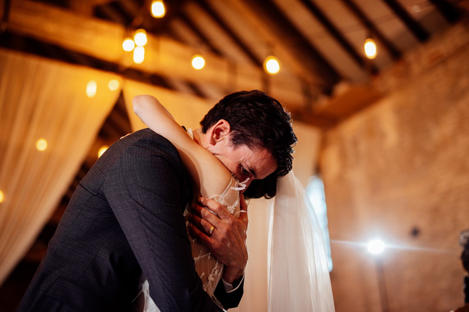 Romantic dance moment captured at an elegant wedding reception with warm lighting and rustic decor.