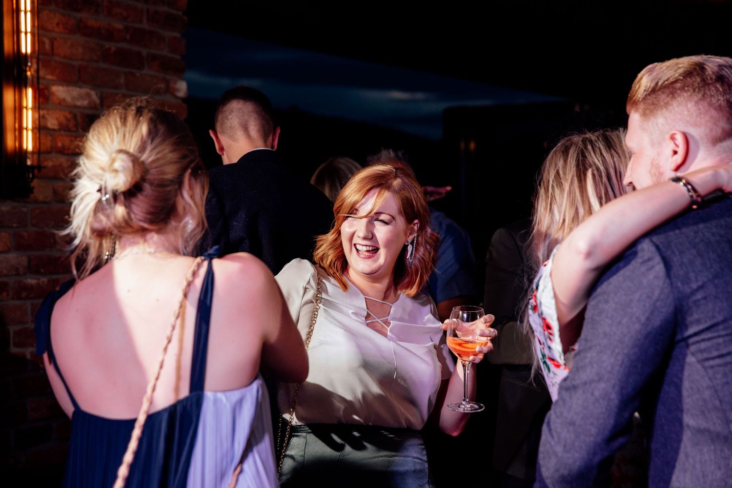 Wedding reception party with warm lighting and dancing guests.