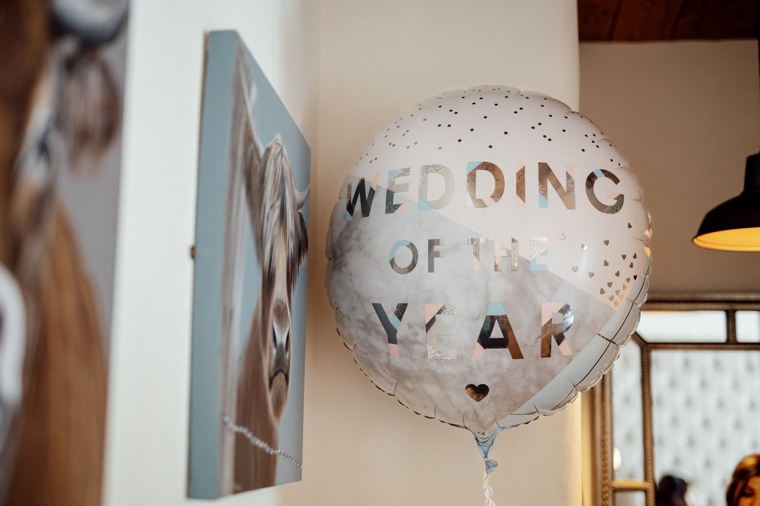 White wedding-themed balloons with text decoration floating against neutral background.