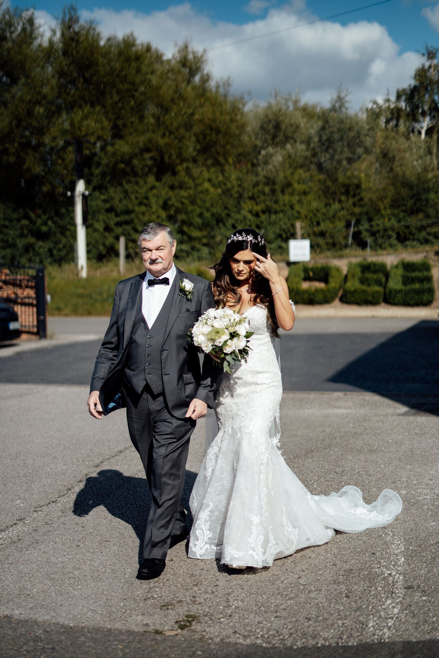 Couple walking and laughing together on sunny outdoor path.