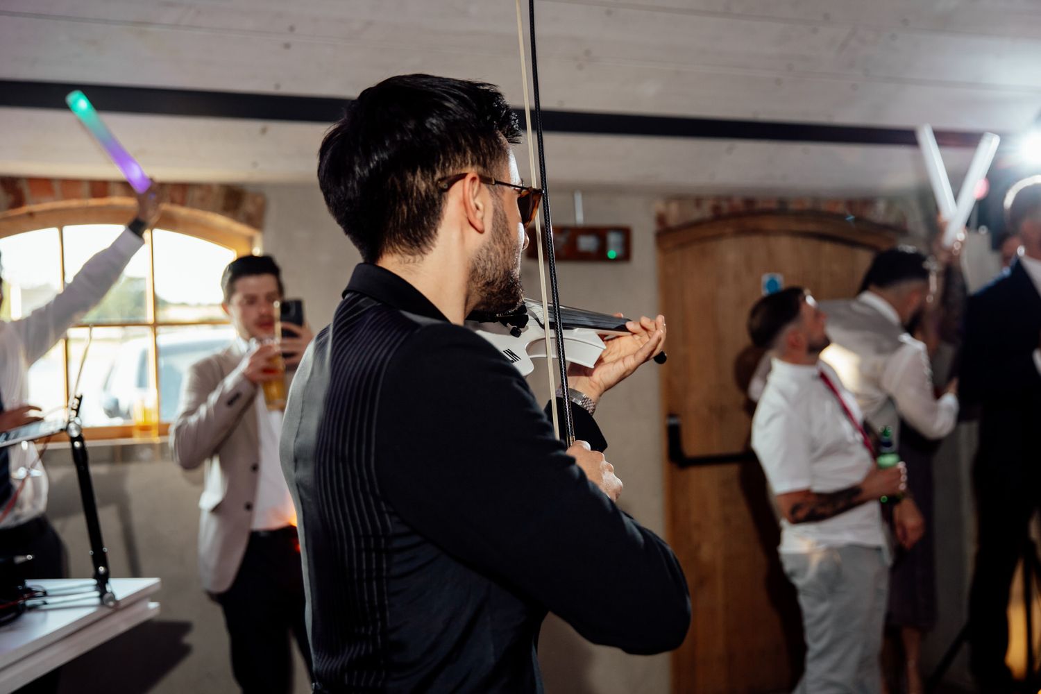Wedding guests dance and celebrate with sparklers during evening reception.