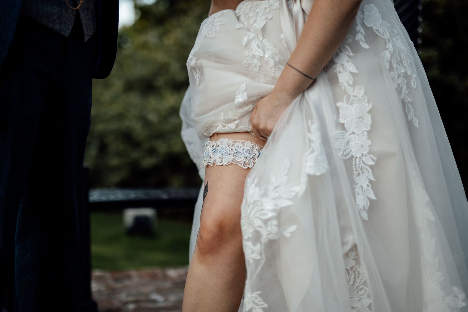 Close-up details of an elegant white lace wedding dress with intricate embroidery.