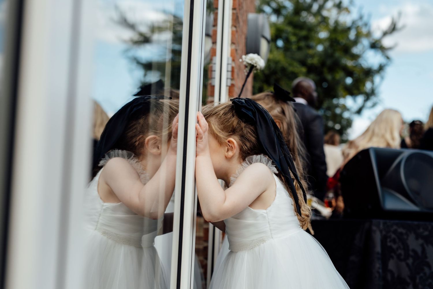 Wedding celebration candid moments captured through window reflections.