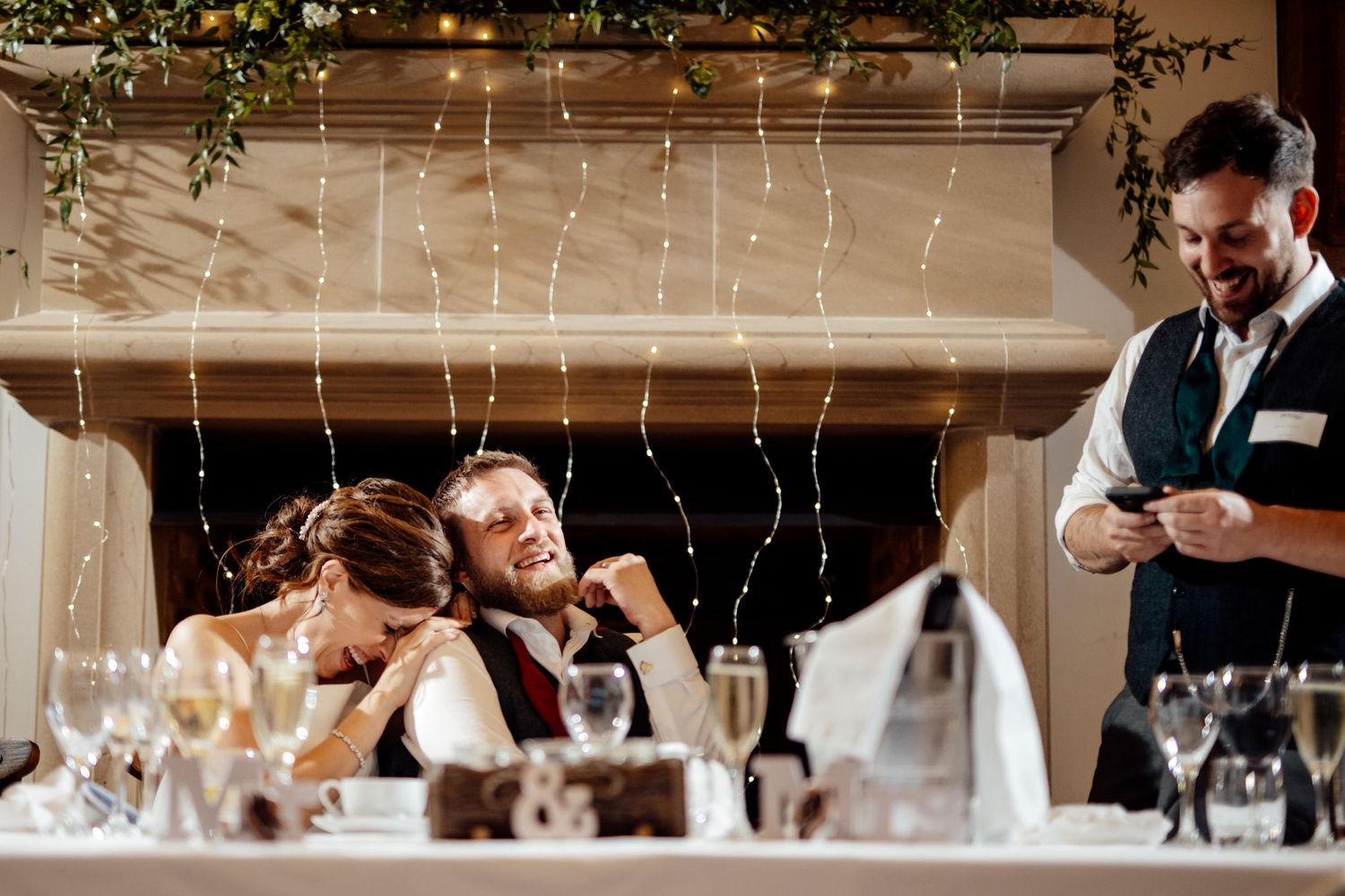 Wedding venue decorated with hanging string lights and rustic wooden beams.