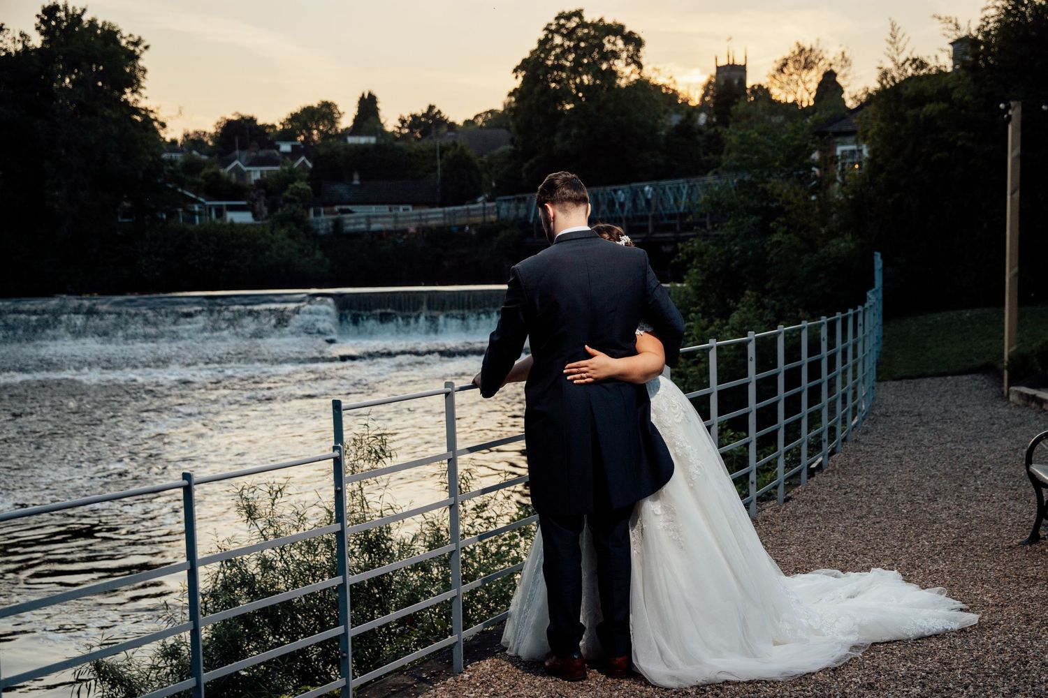 Sunset waterfront wedding photos with couple silhouetted against evening sky.