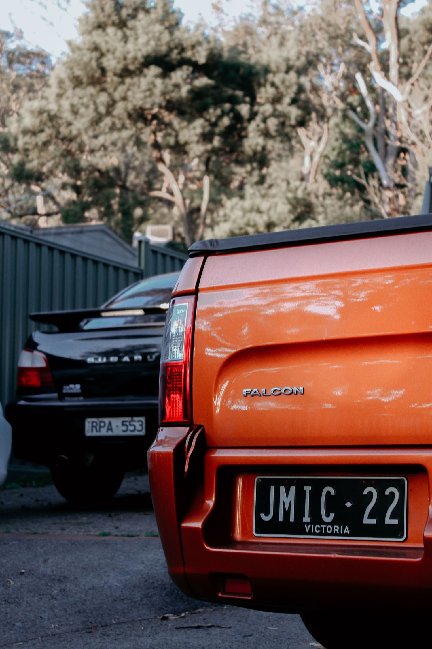 Classic orange Ford Falcon XB with vintage Victoria license plate JMIC-22 parked outdoors.