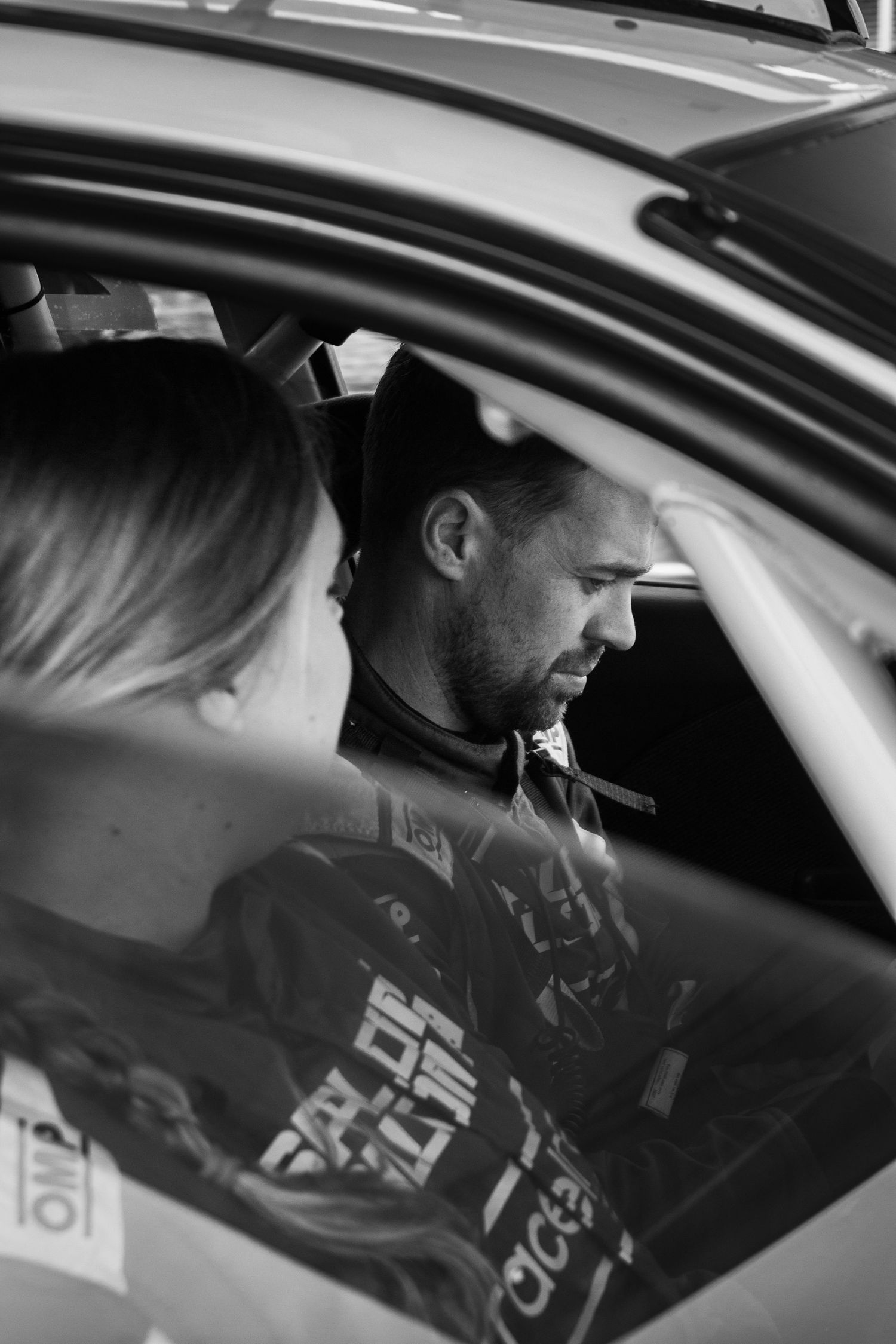 View inside a race car showing two people in the front seats.