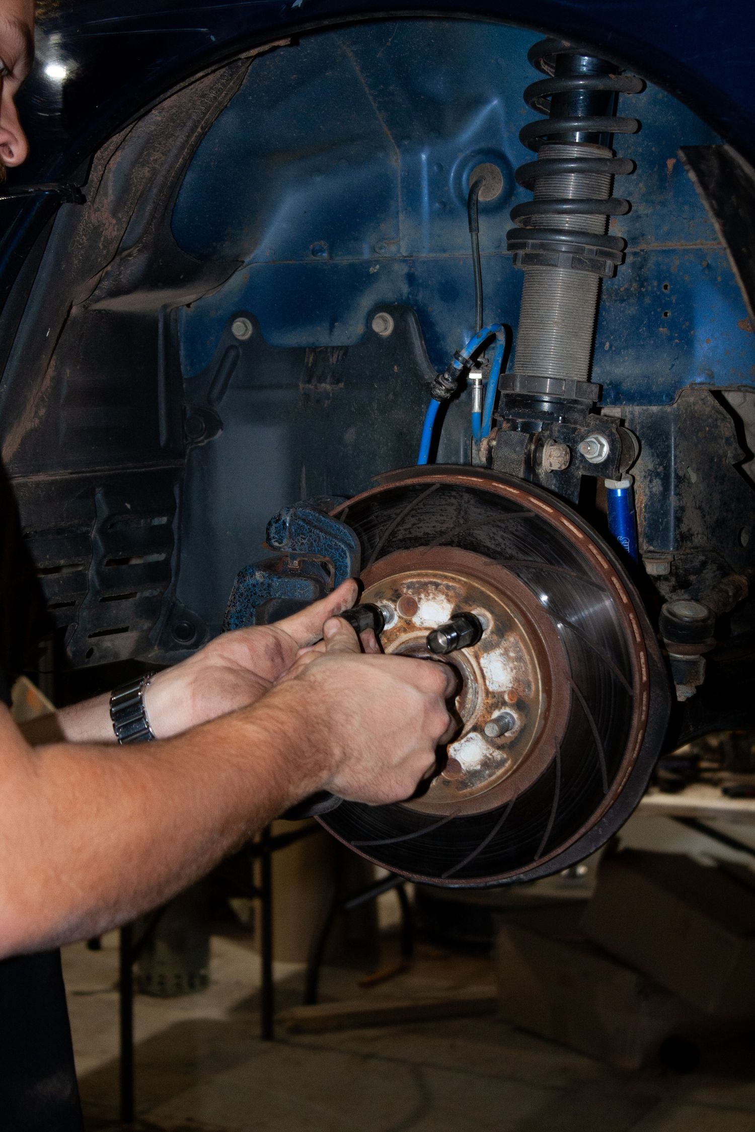 Close-up sequence of hands working on car brake components during maintenance.