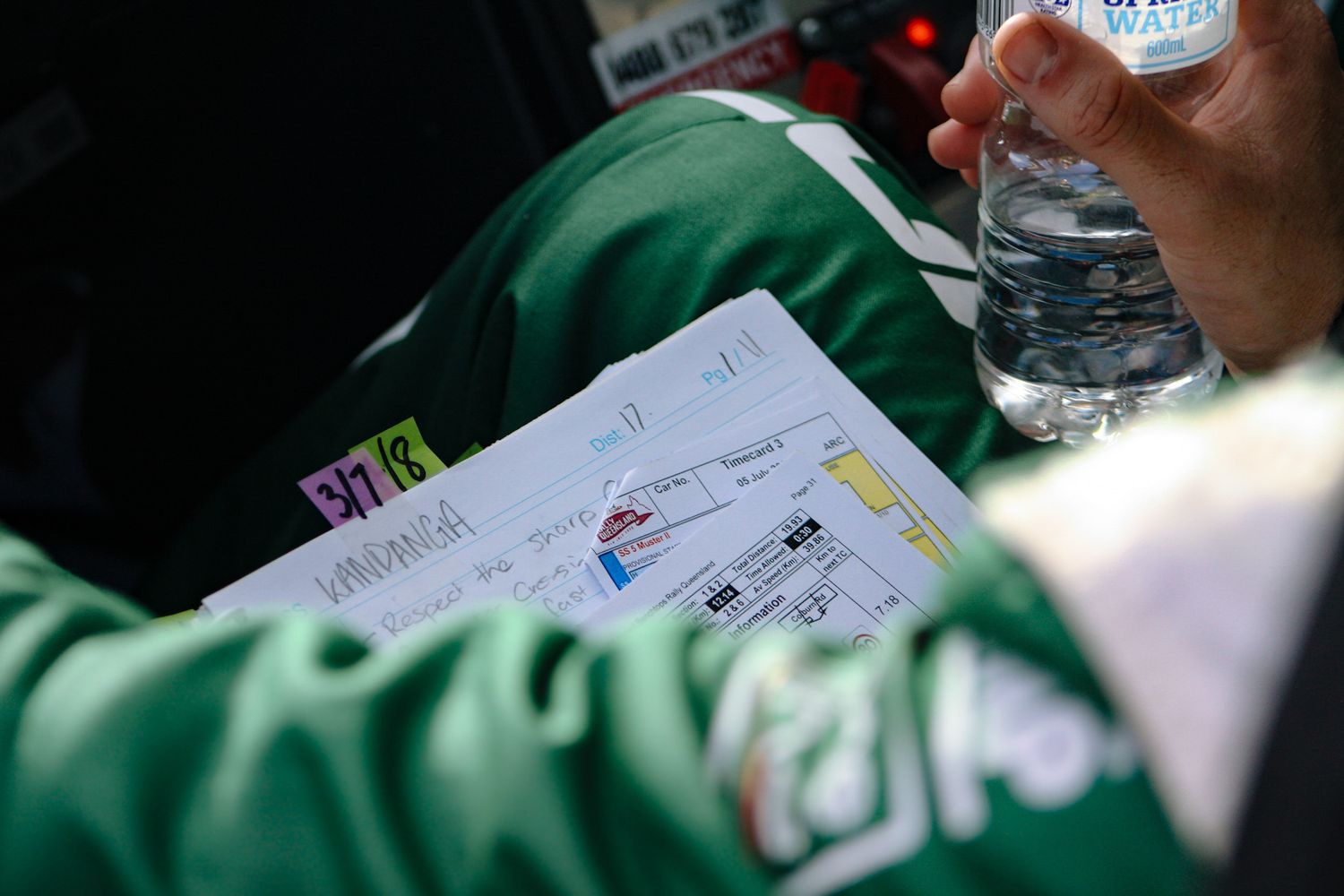 Close-up of racing documents and paperwork being reviewed during a rally event.