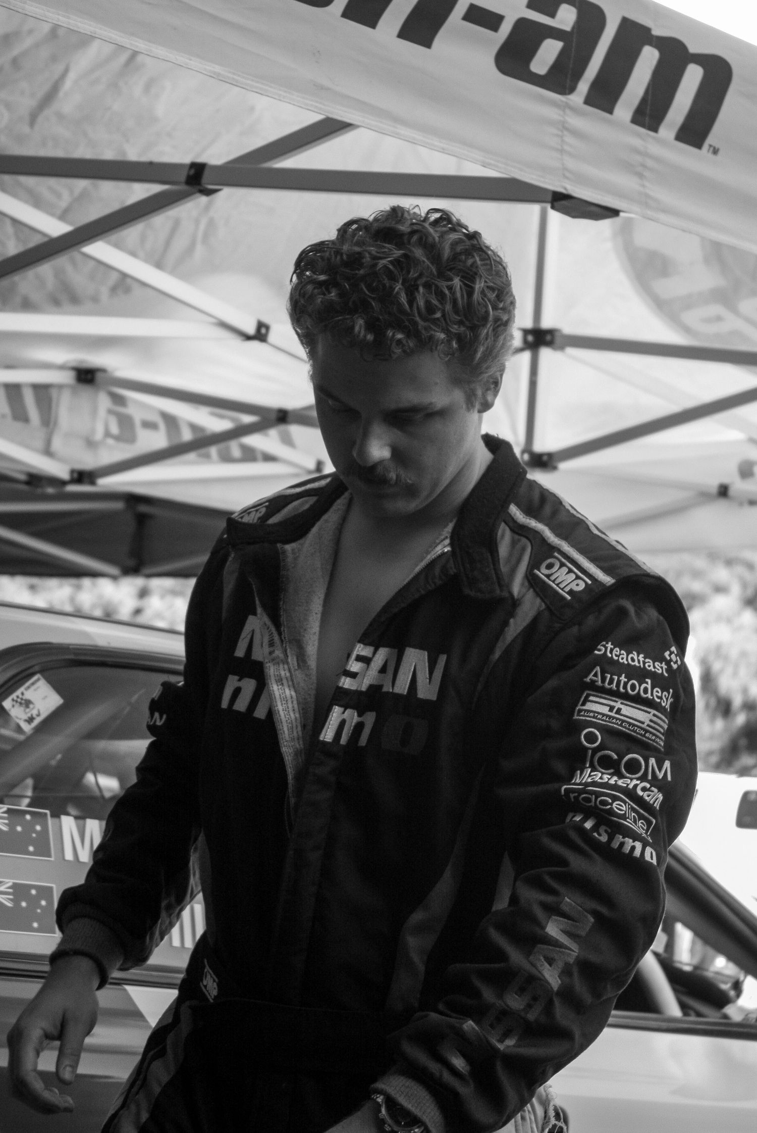 Racing team crew member in black uniform preparing for event.