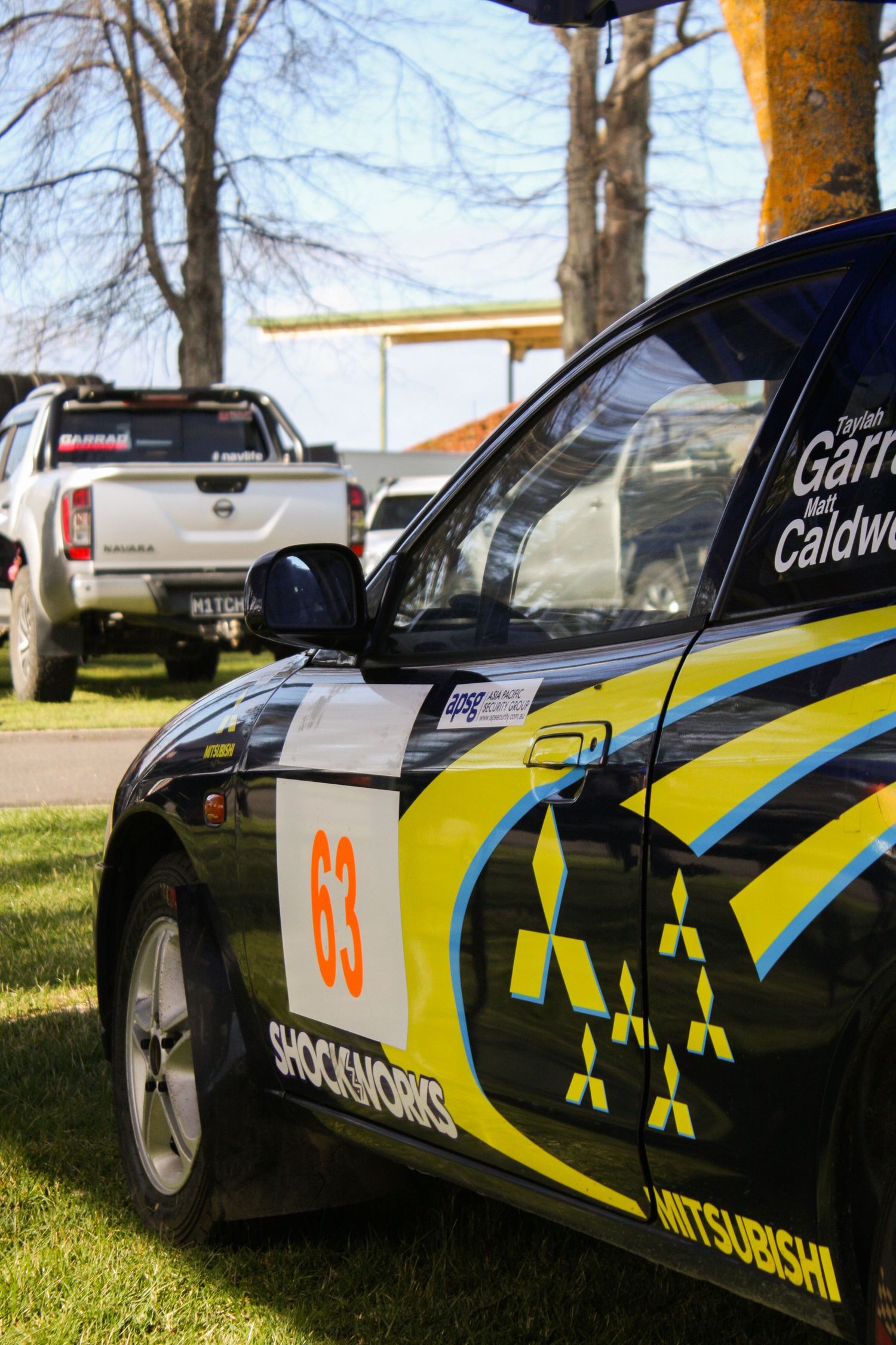 Racing car livery featuring yellow and black graphics with competition numbers.