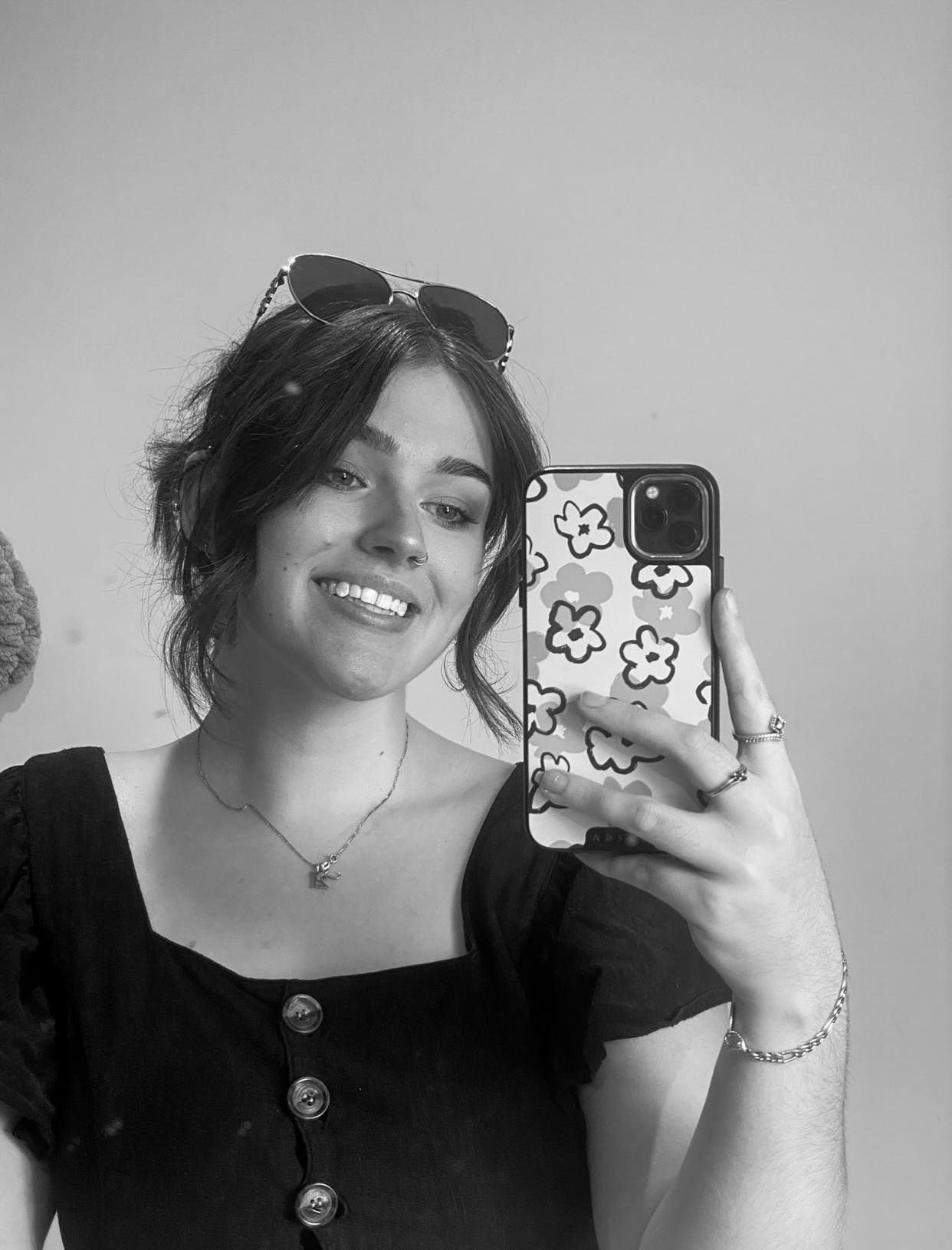 Series of selfies taken with a phone showing floral phone case and black outfit.