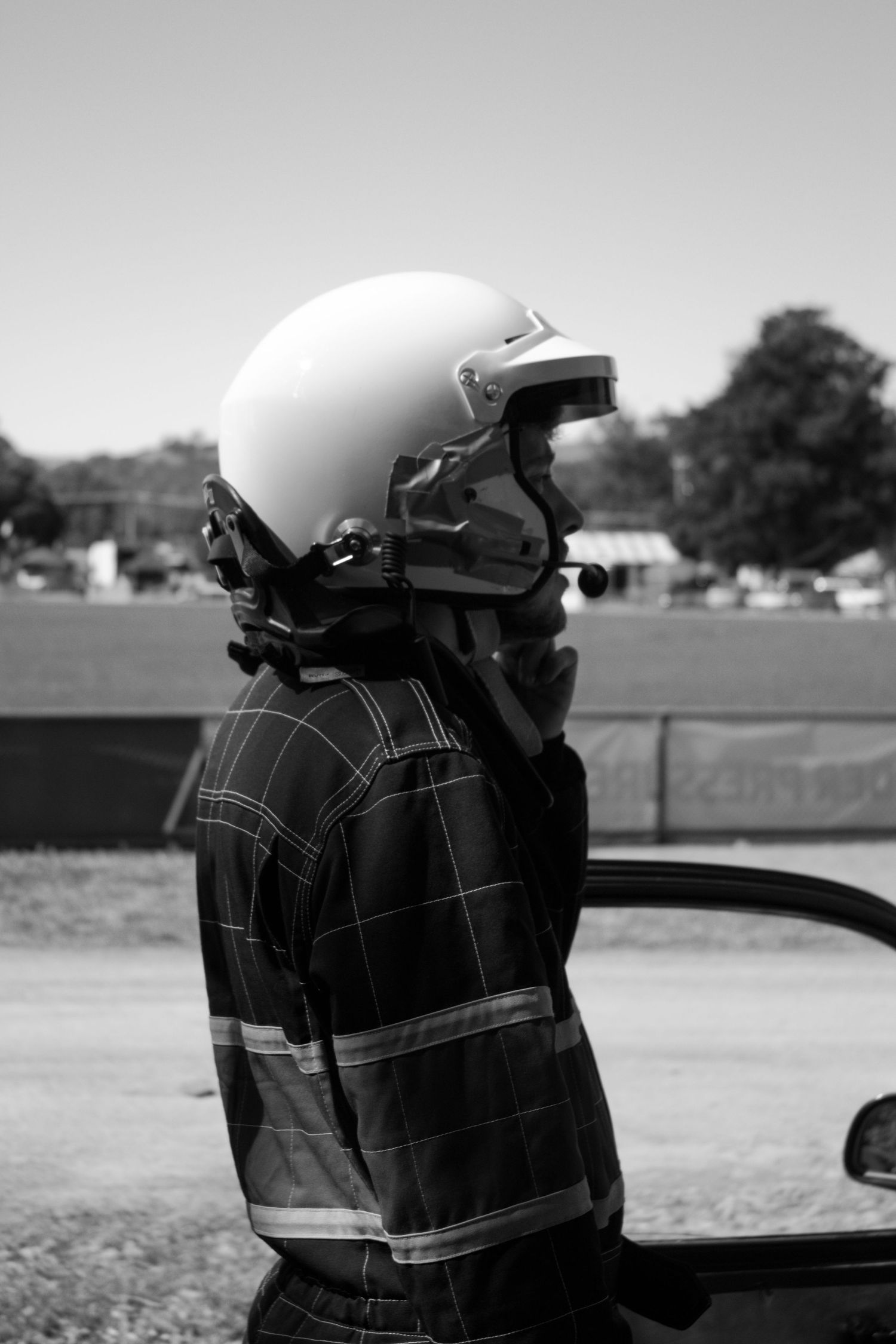 Racing helmet and safety gear shown in black and white profile view.