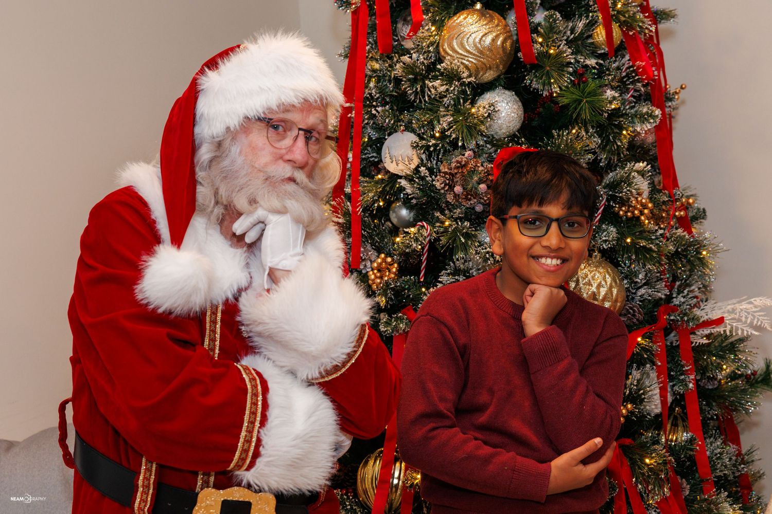 Holiday family photography featuring Santa Claus and a young boy in Bethesda, MD. Festive event portrait by Neamography.