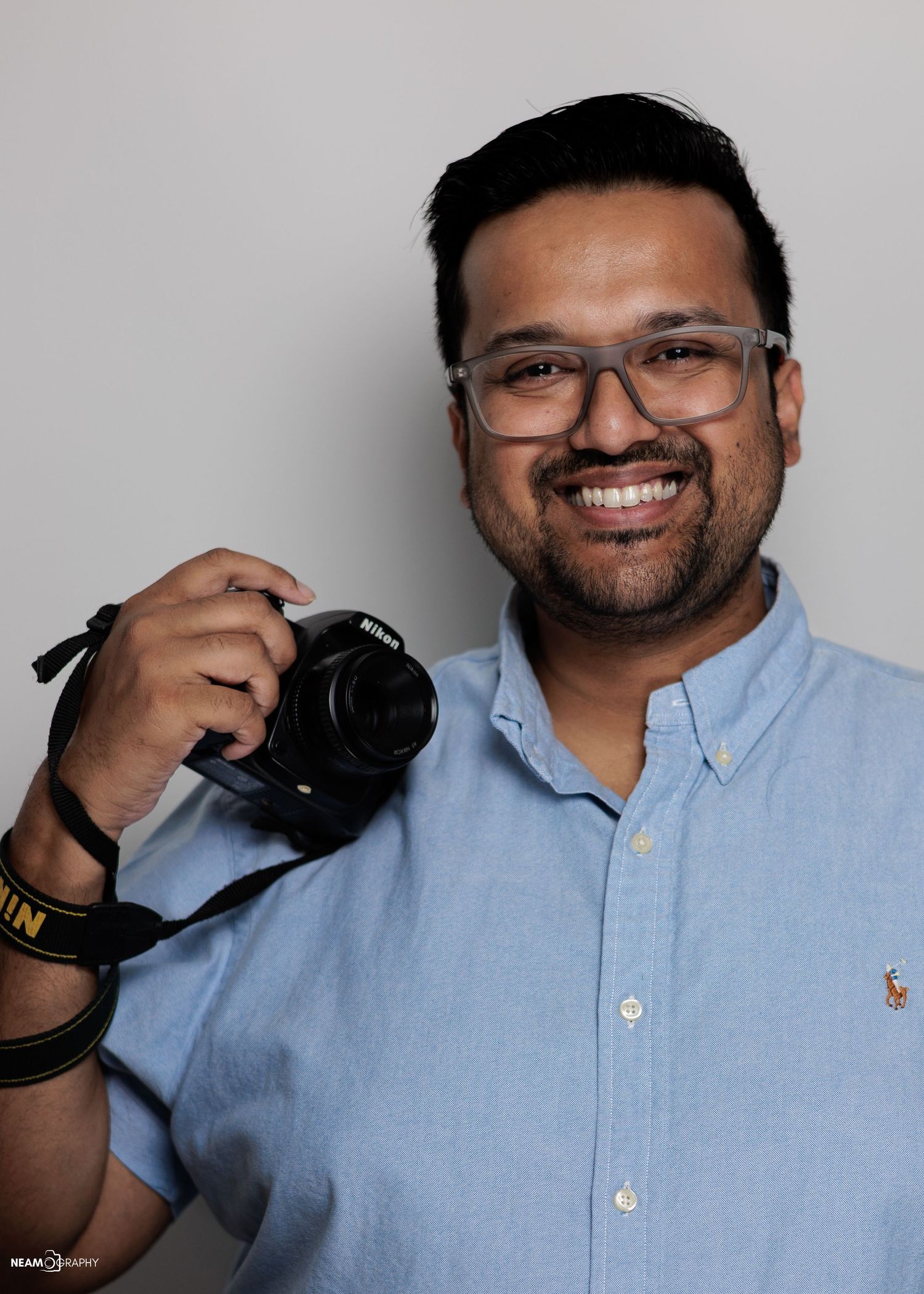 Professional headshot of Neam Ul Islam, Lead Photographer of Neamography in Rockville, MD, wearing a black suit and tie.