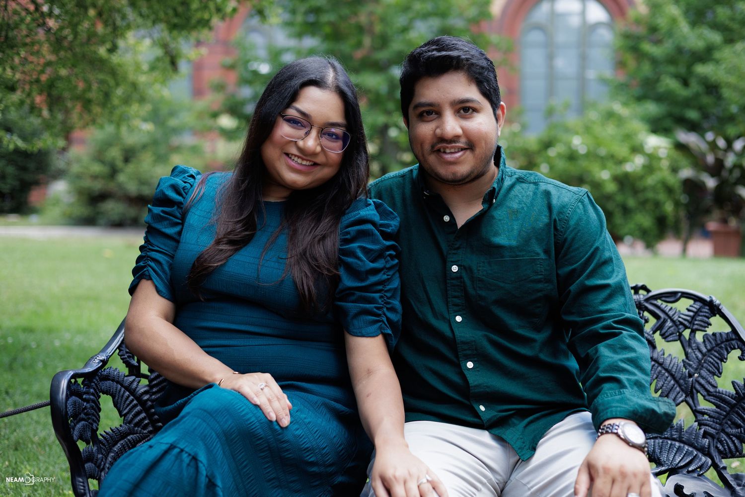 South Asian couple posing at Enid A. Haupt Garden in DC, featuring vibrant traditional attire and lush greenery for a wedding session.