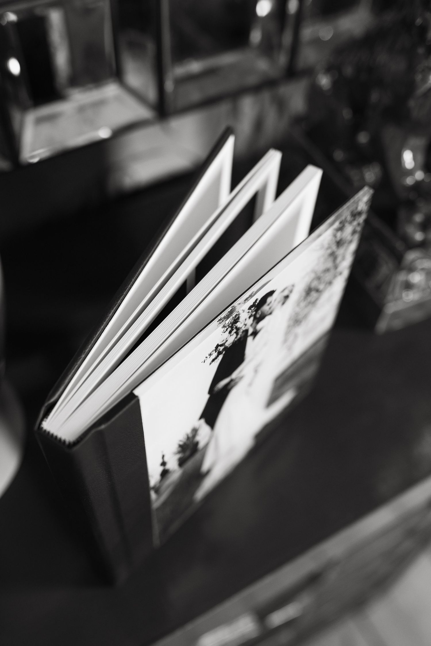 Black and white close-up photograph of an open book's pages with a blurred background.