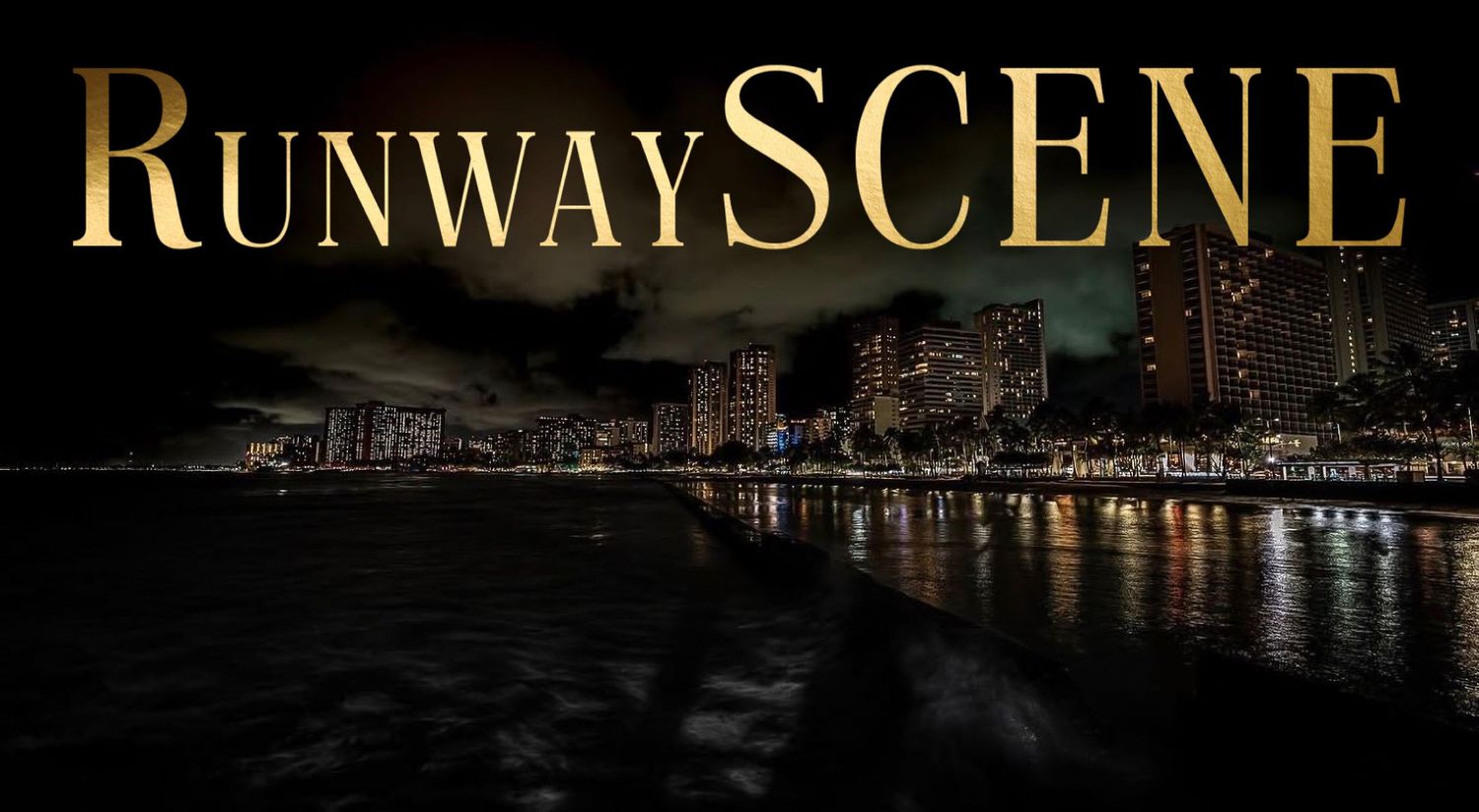 Glittering city skyline at night reflects on dark water with illuminated buildings and bridges.
