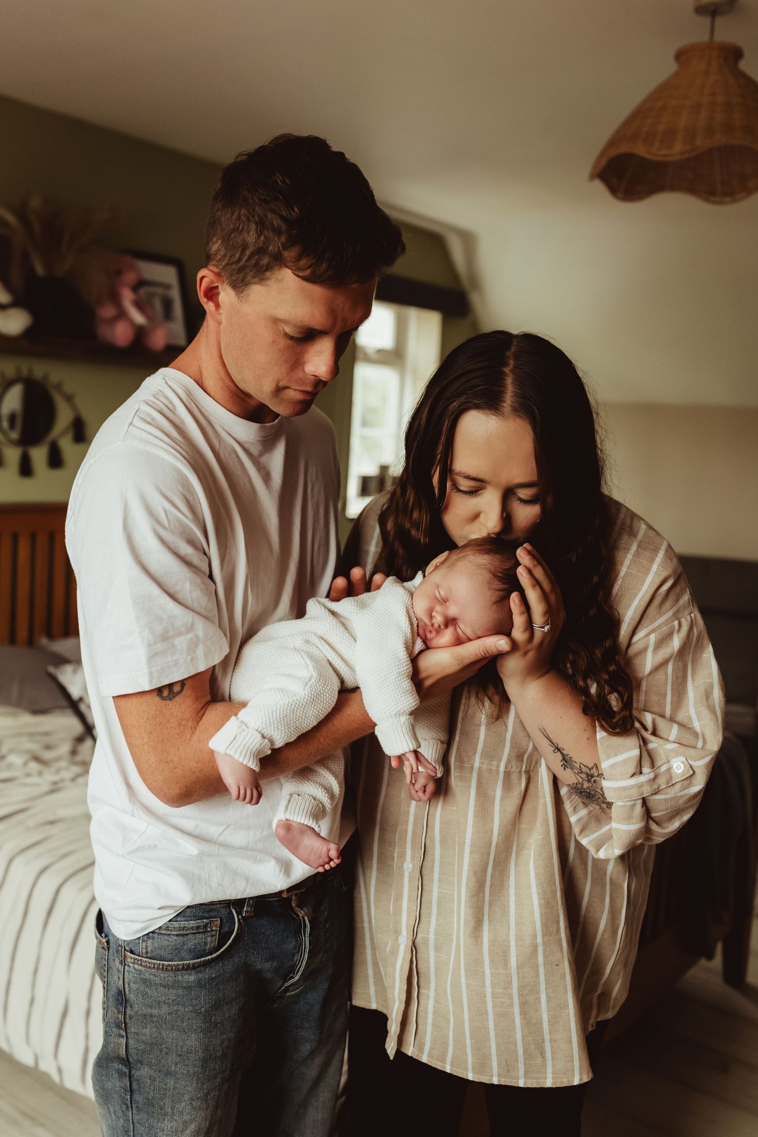 A tender family moment captured in a series of intimate lifestyle photos showing parents bonding with their baby at home.