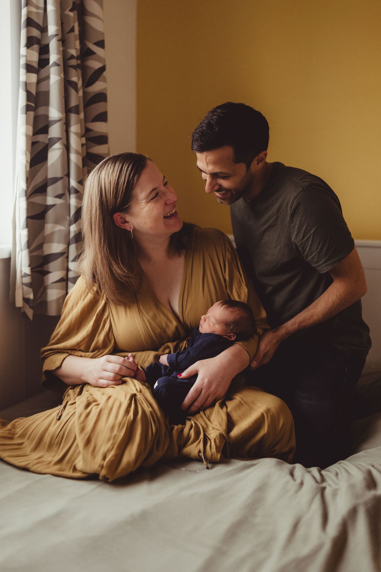 A couple shares intimate moments together while relaxing on a bed in a warmly lit room.