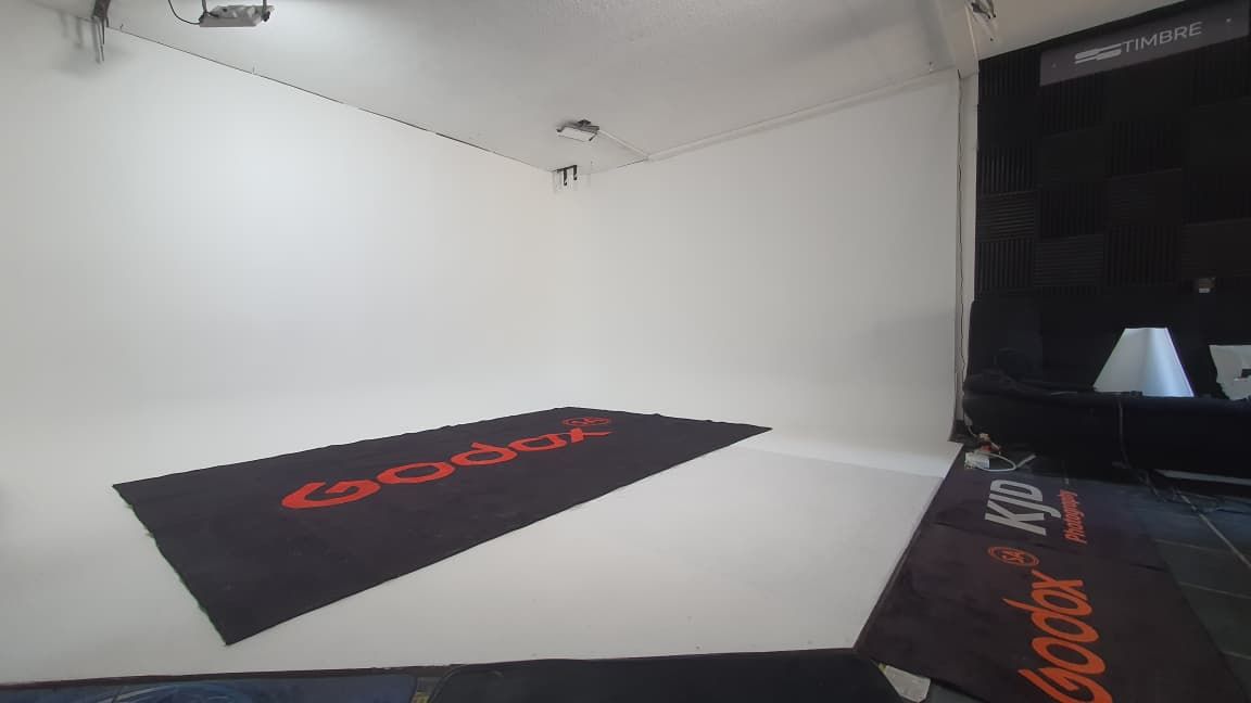 A sleek black gaming mat with red accents lies on a white surface in a dimly lit room.