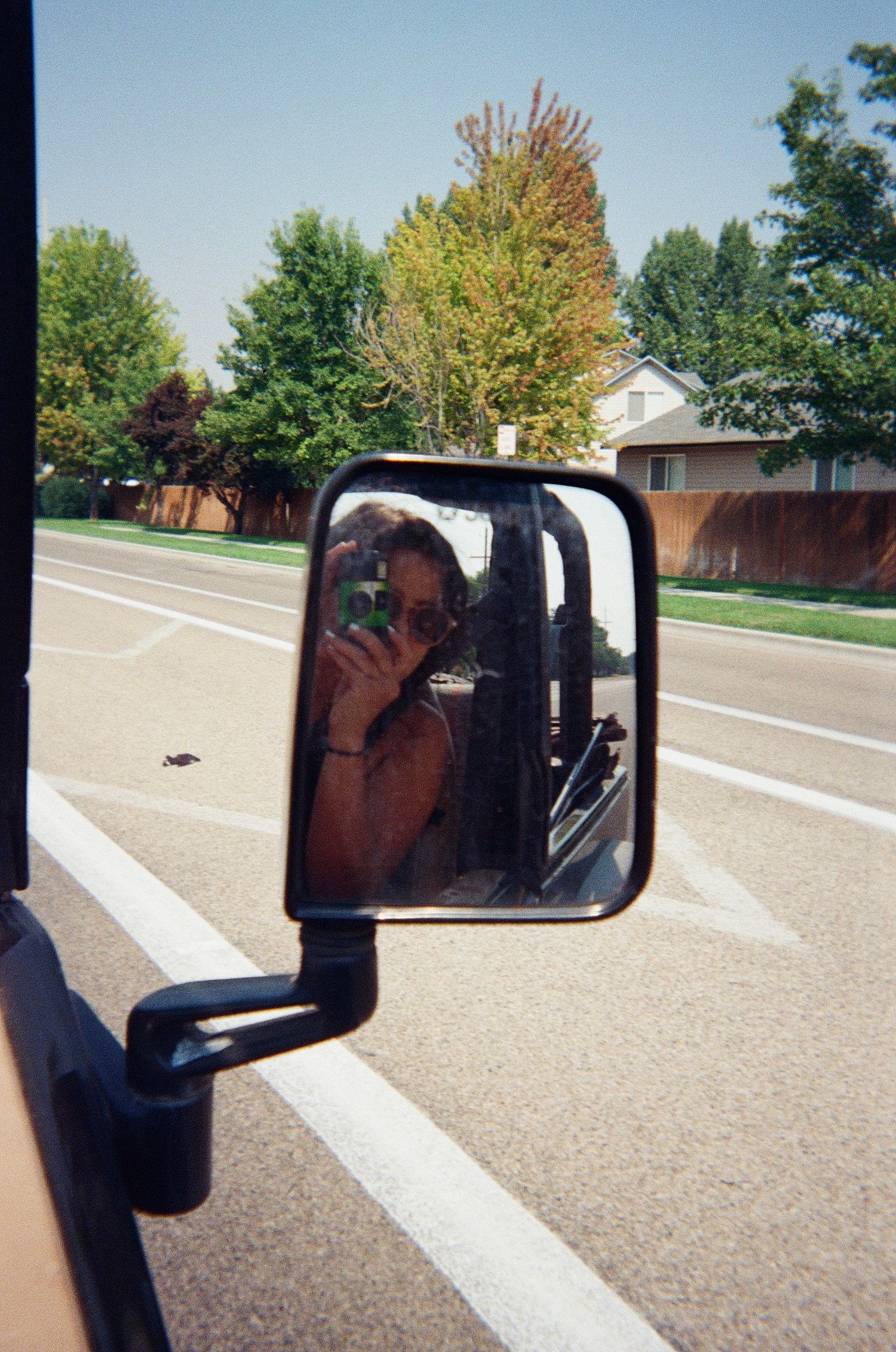 A reflection in a truck's side mirror shows someone taking a photo.