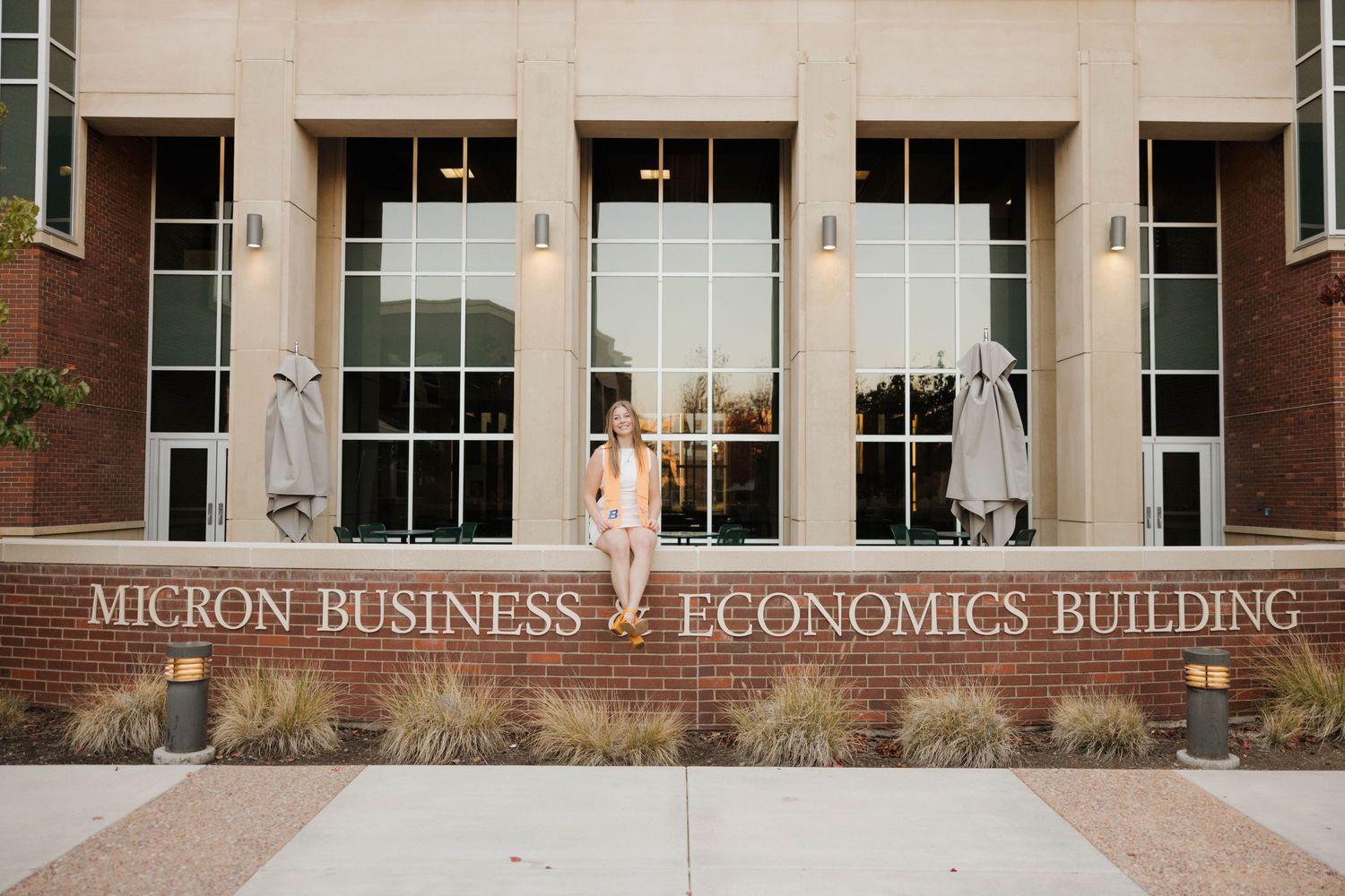 The entrance to the Micron Business & Economics building featuring tall glass windows and modern brick architecture.