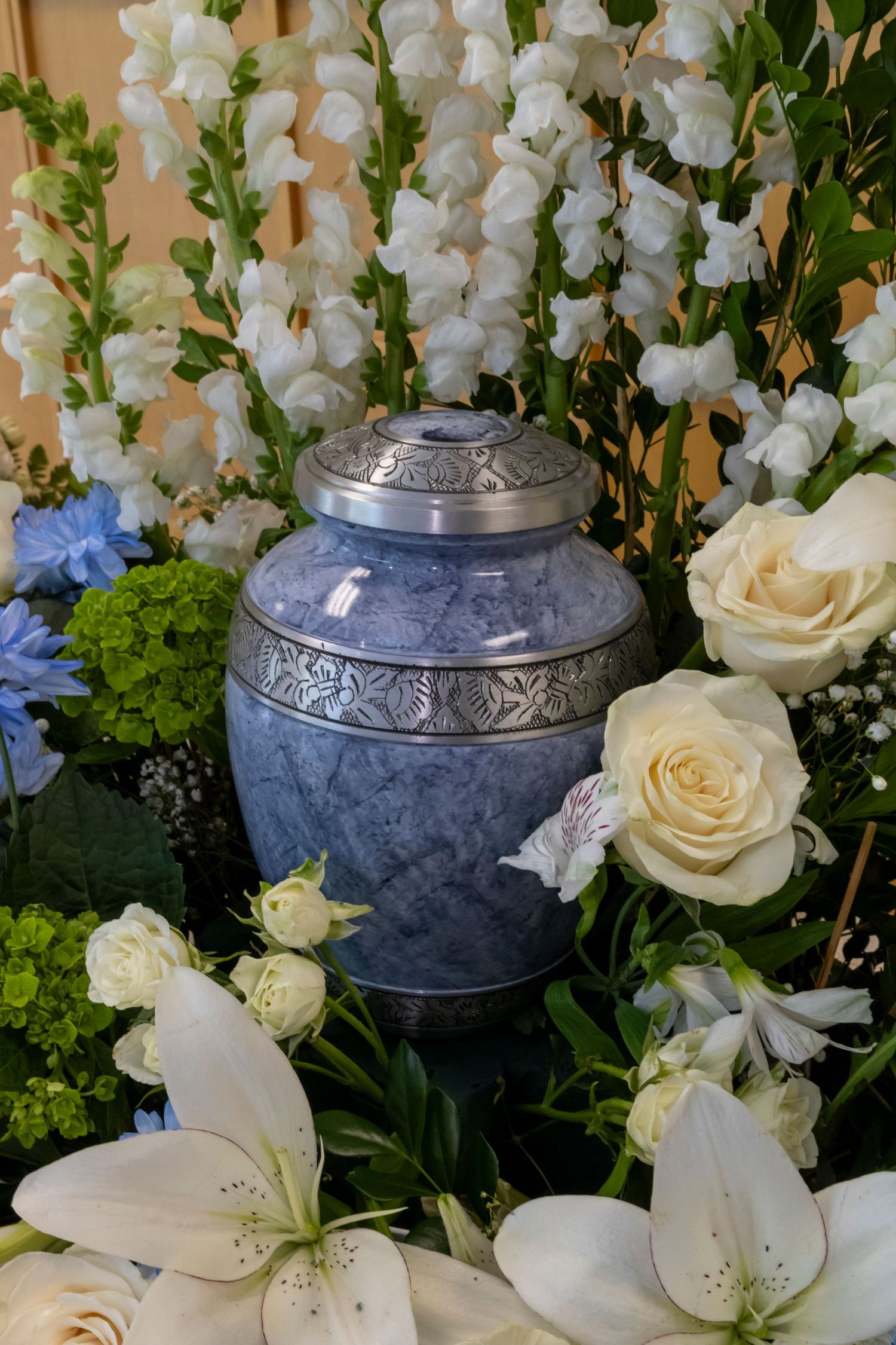 Blue urn surrounded by white flowers