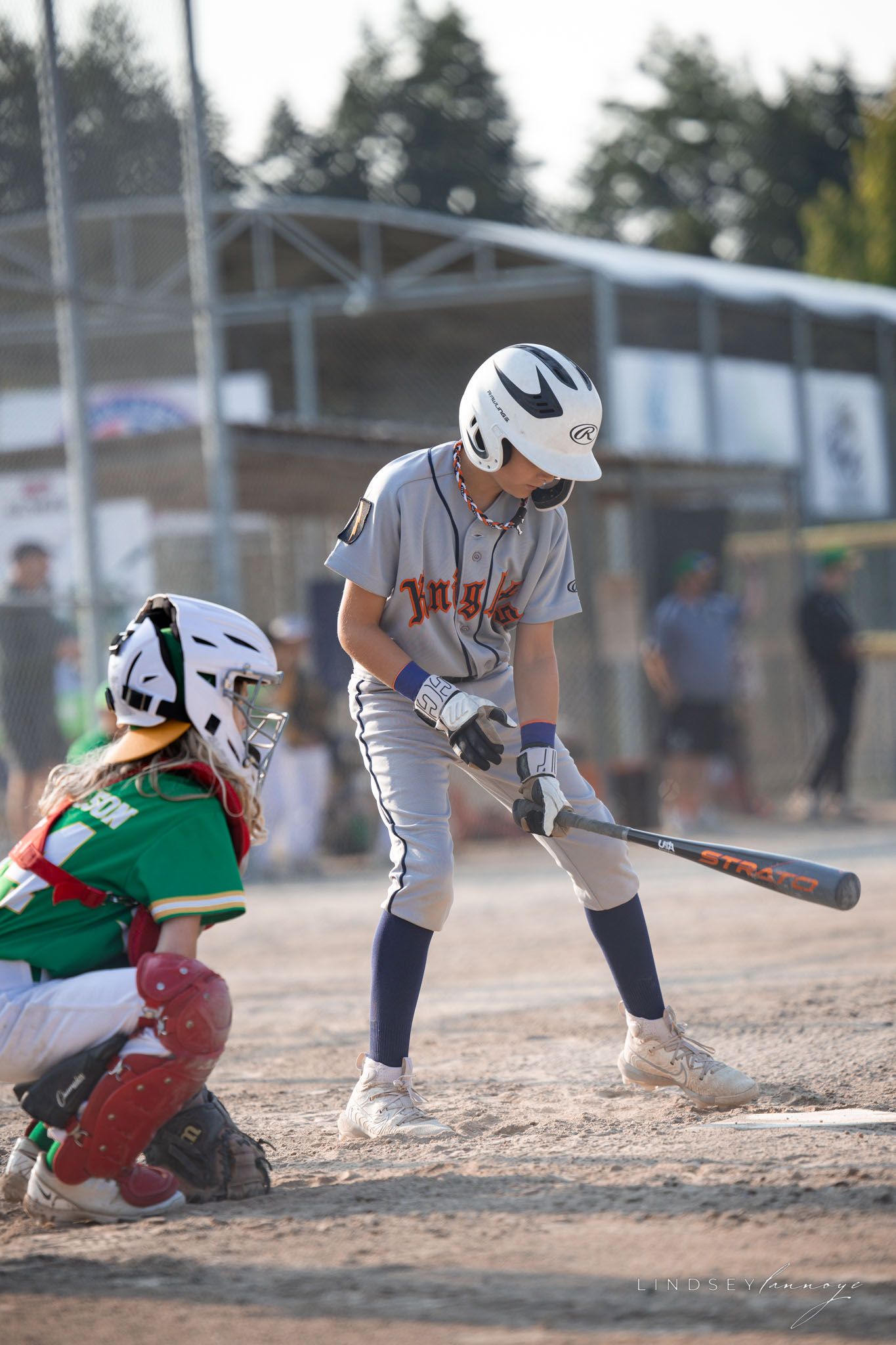 Young Knights batter in gray uniform prepares to swing as catcher crouches during a youth baseball game.