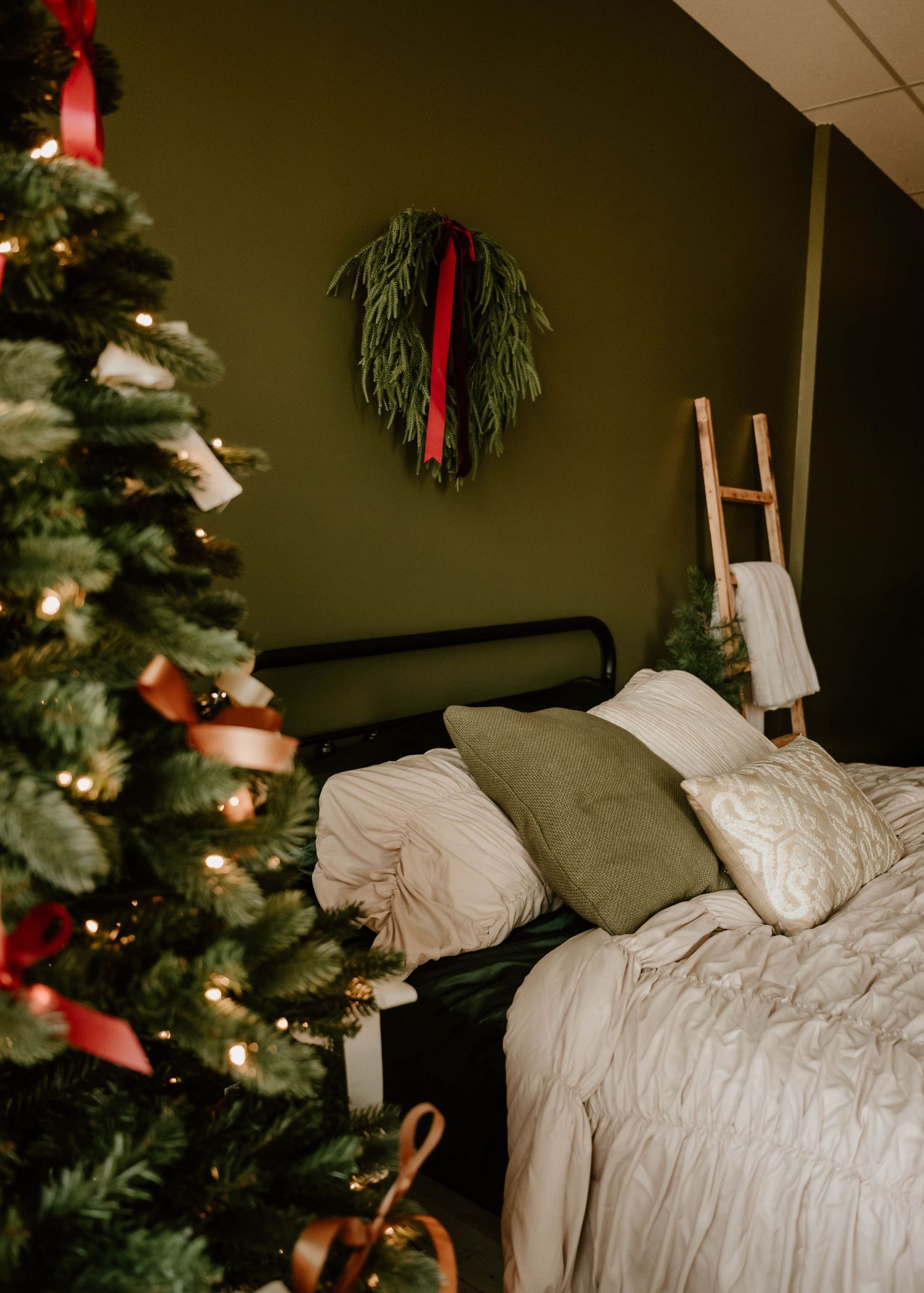 Festive Christmas photography setup featuring a styled bed, decorated tree, and holiday décor available for photographers at Everwild