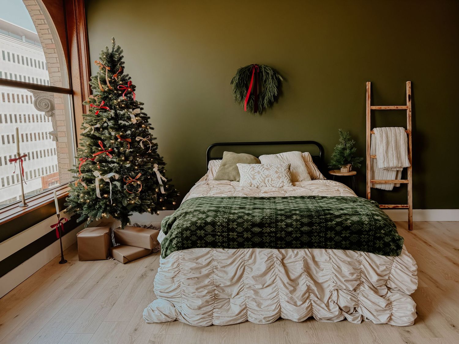 Cozy Christmas bedroom photography setup with a decorated tree, styled bed, and holiday décor at Everwild Collective Studio in Spokane, WA